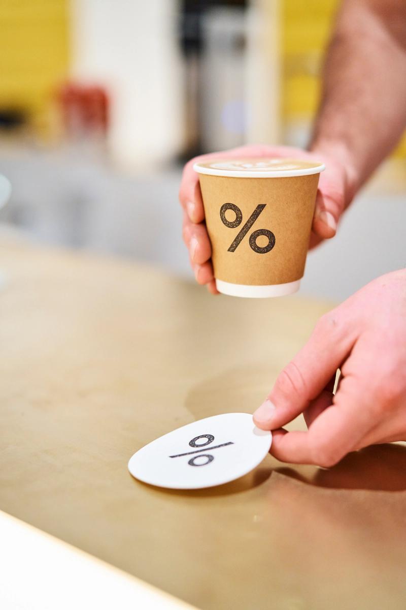 coffee cup being served with % Arabica logo
