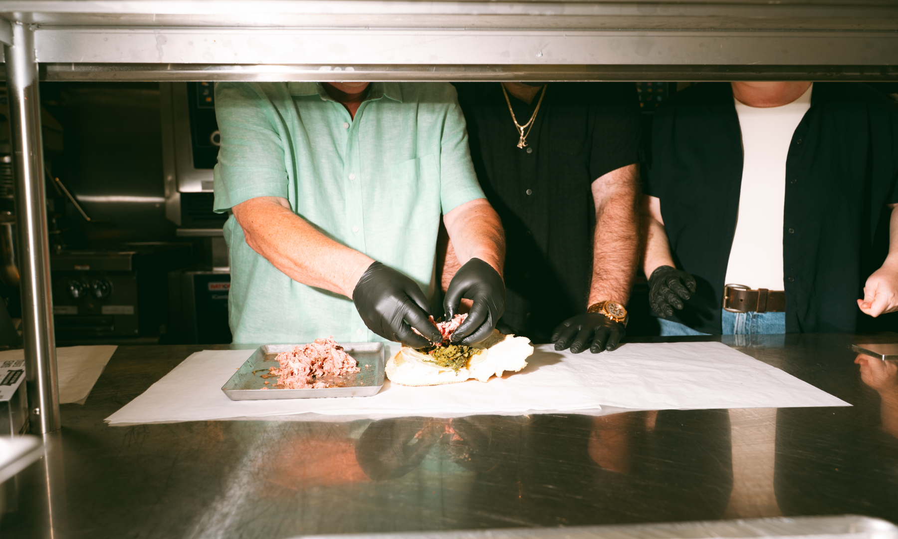 Mark, Brian, and Joey Lobel making a sandwich at Lobel's Original