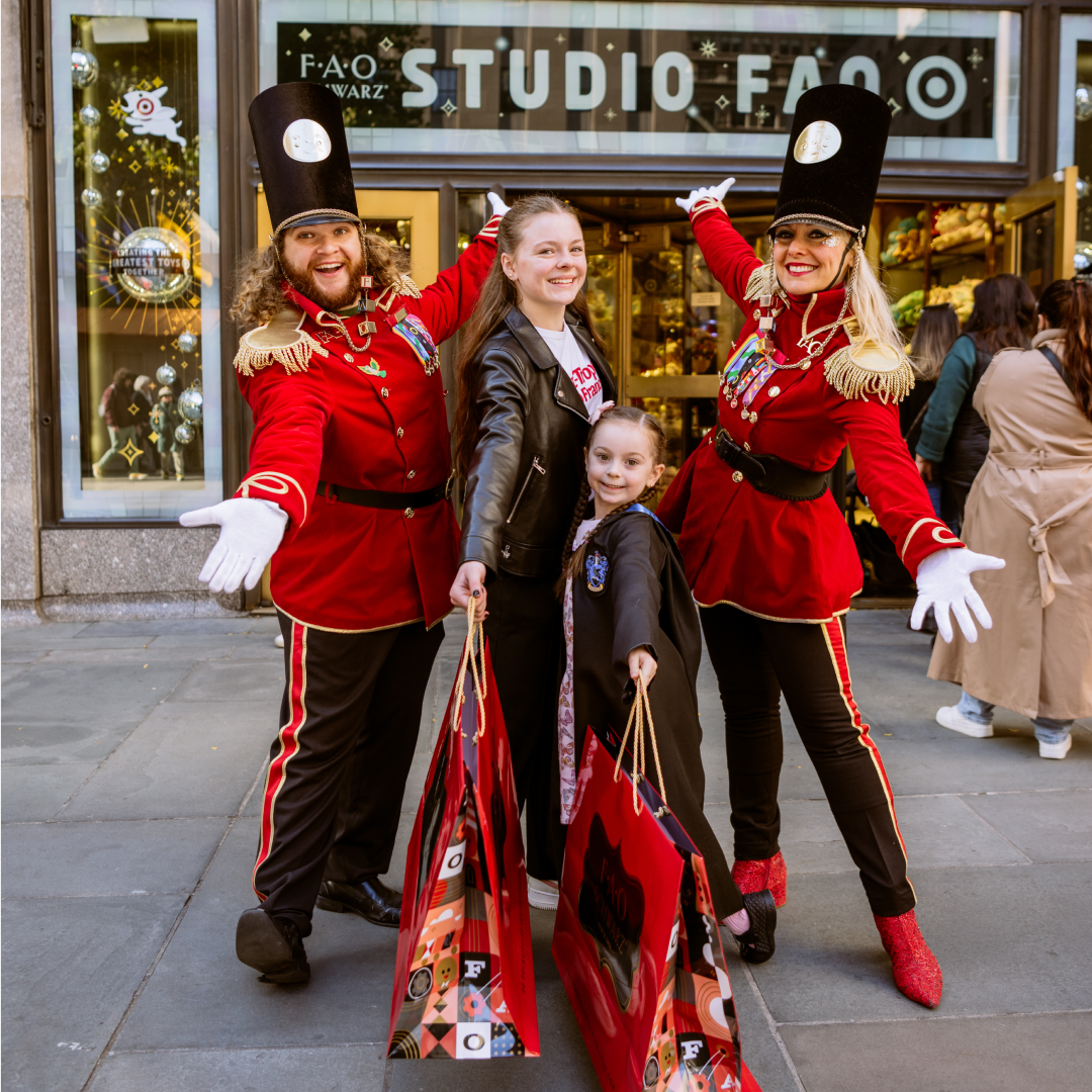 Two children posing with two FAO Schwarz toy soldiers
