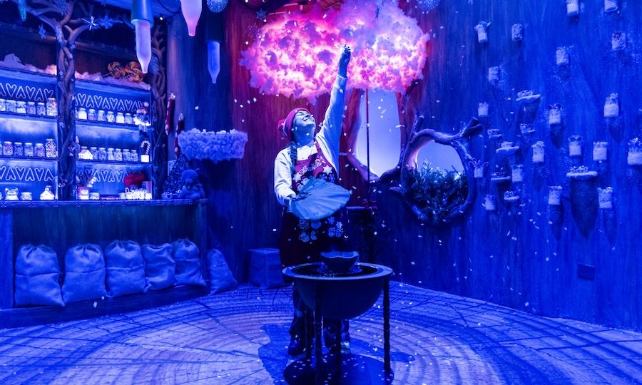 Candy Cottage of Christmas Magic employee touching a cloud