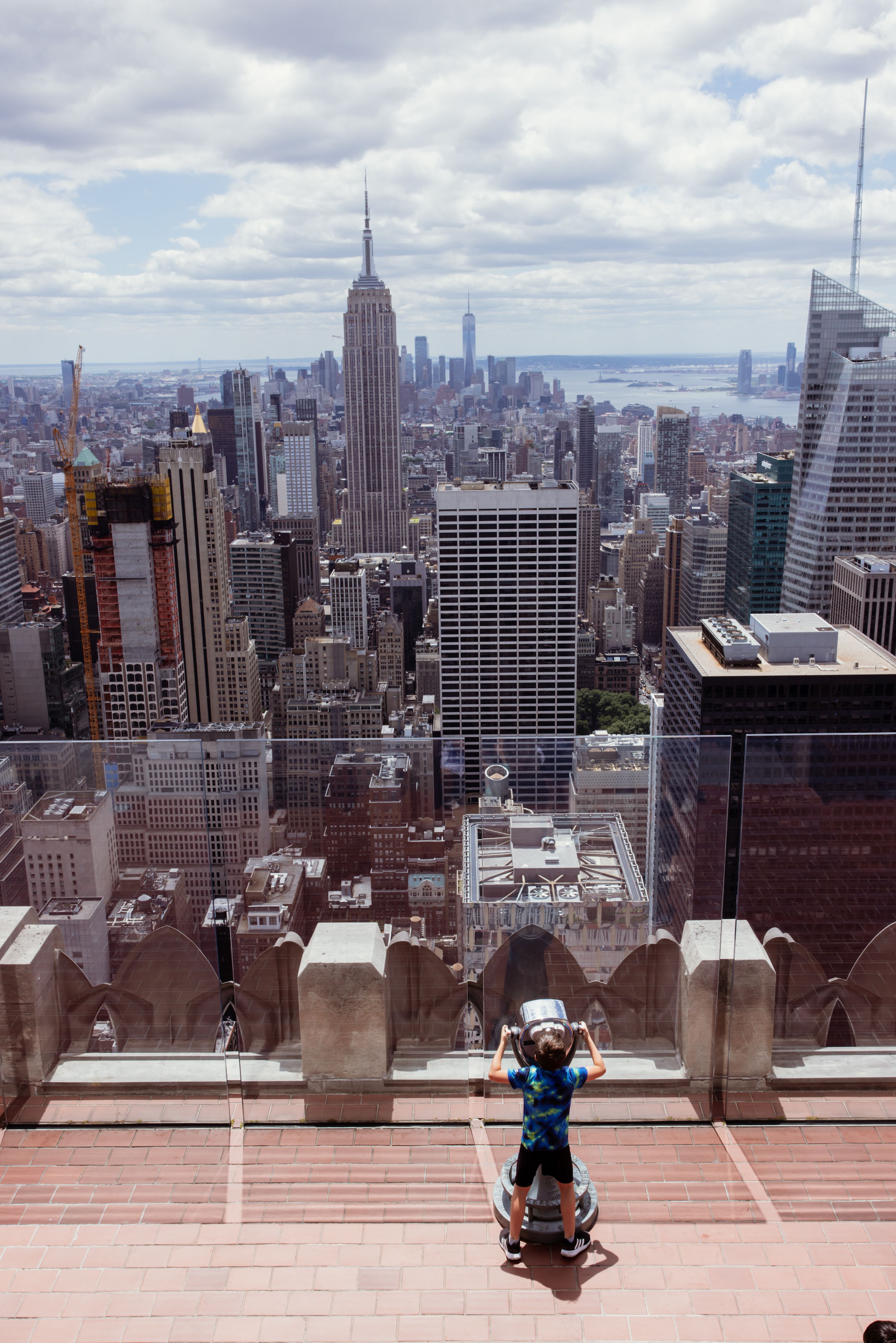 A visitor looking out over Midtown Manhattan from the Top of the Rock observation deck.