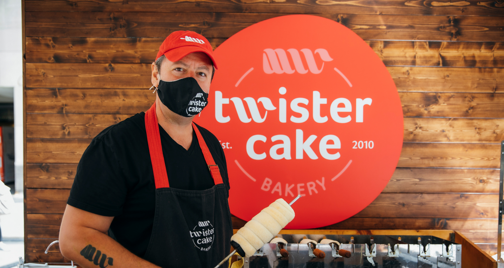 A employee standing in the Twister Cake stand at the Queens Night Market Outpost at Rockefeller Center 