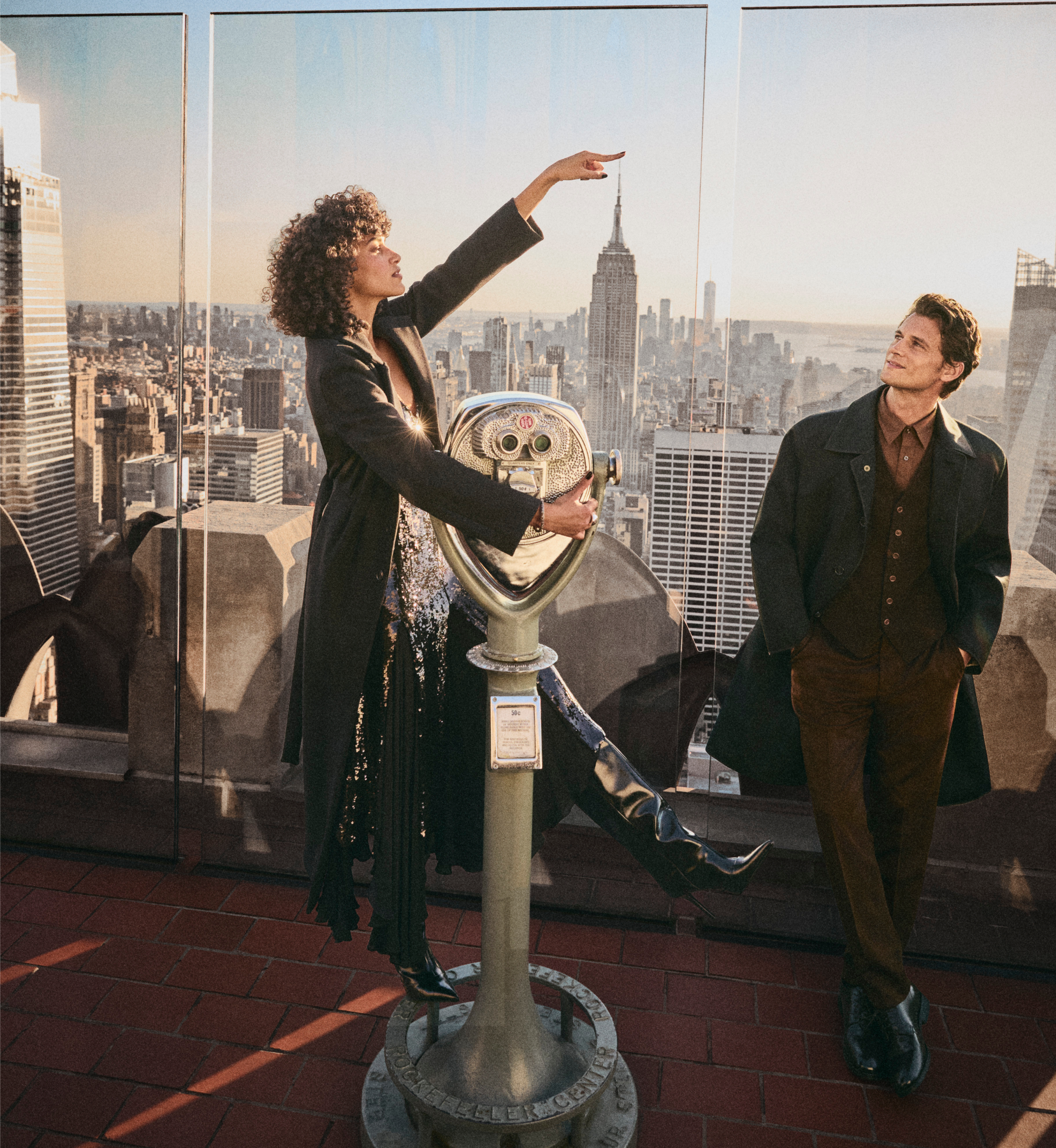 A woman and a man visiting Top of the Rock at sunset