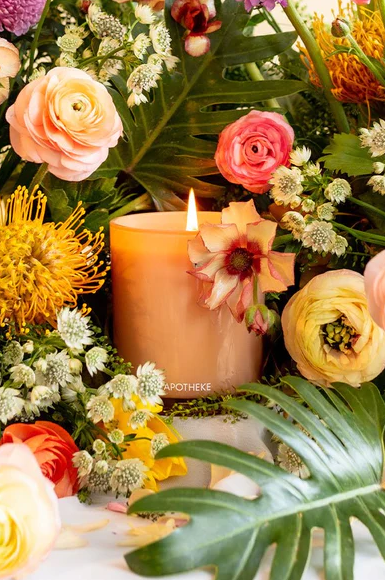 Candle surrounded by flowers