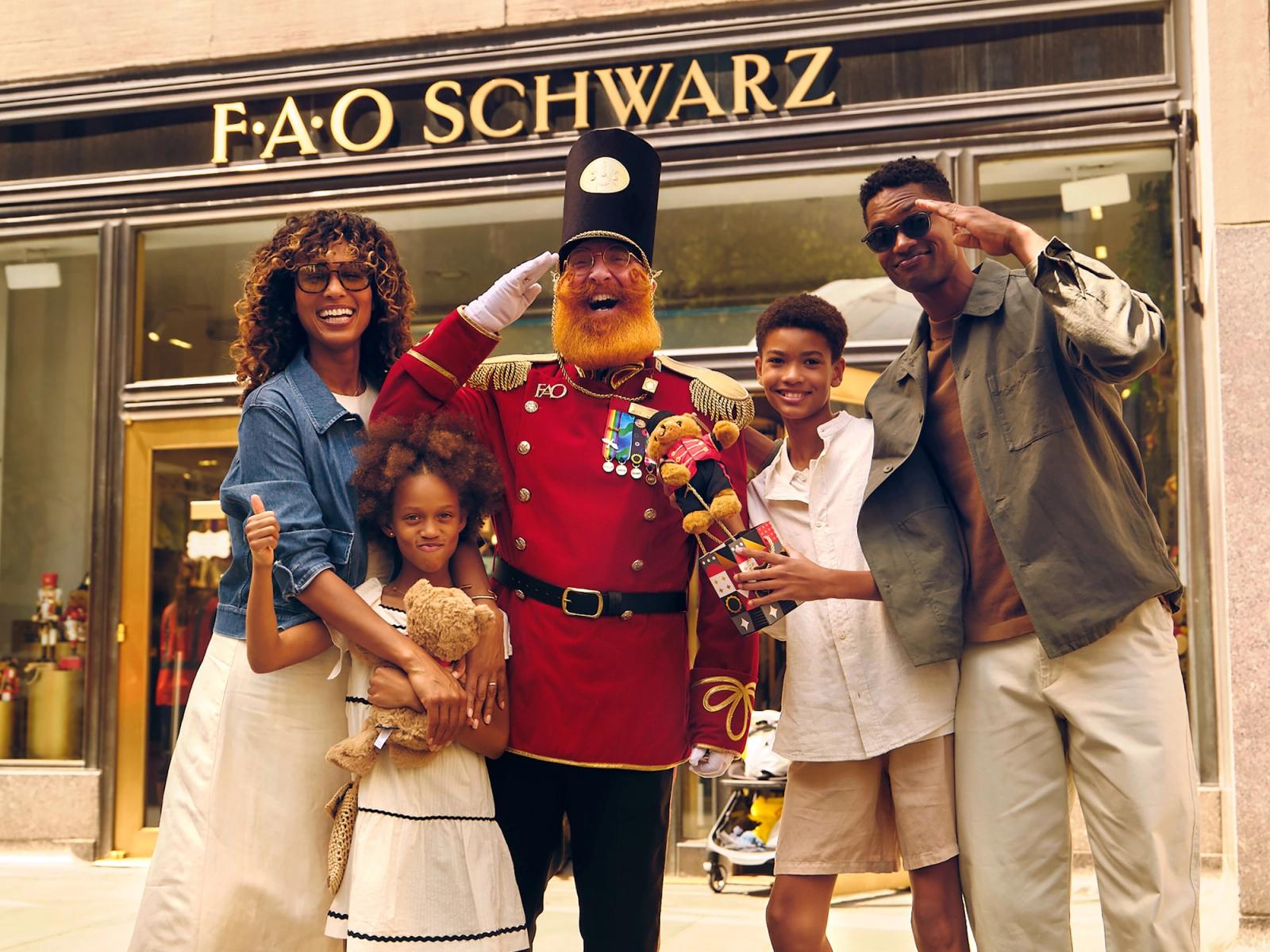 Man in traditional British officer costume flanked by a woman and child jumping