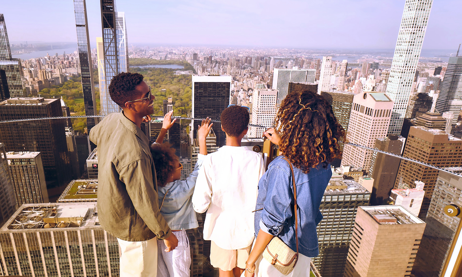 A family of four enjoying the view of NYC from Skylift at Top of the Rock