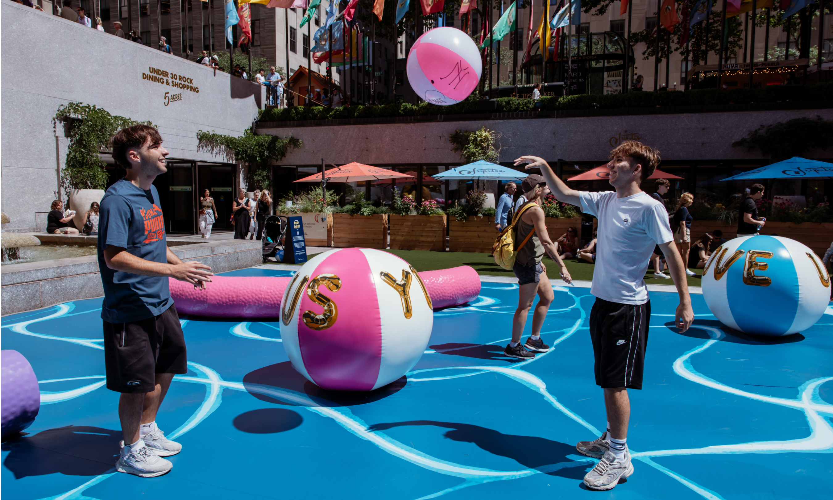 Two teenagers playing with a beach ball at Joel Mesler's "Pool Party"