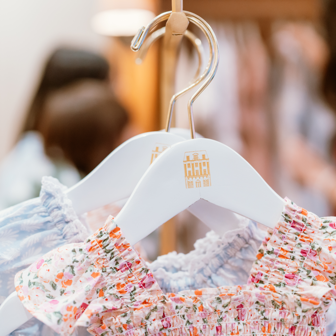 A close-up of two dresses hanging on a rack at Hill House Home