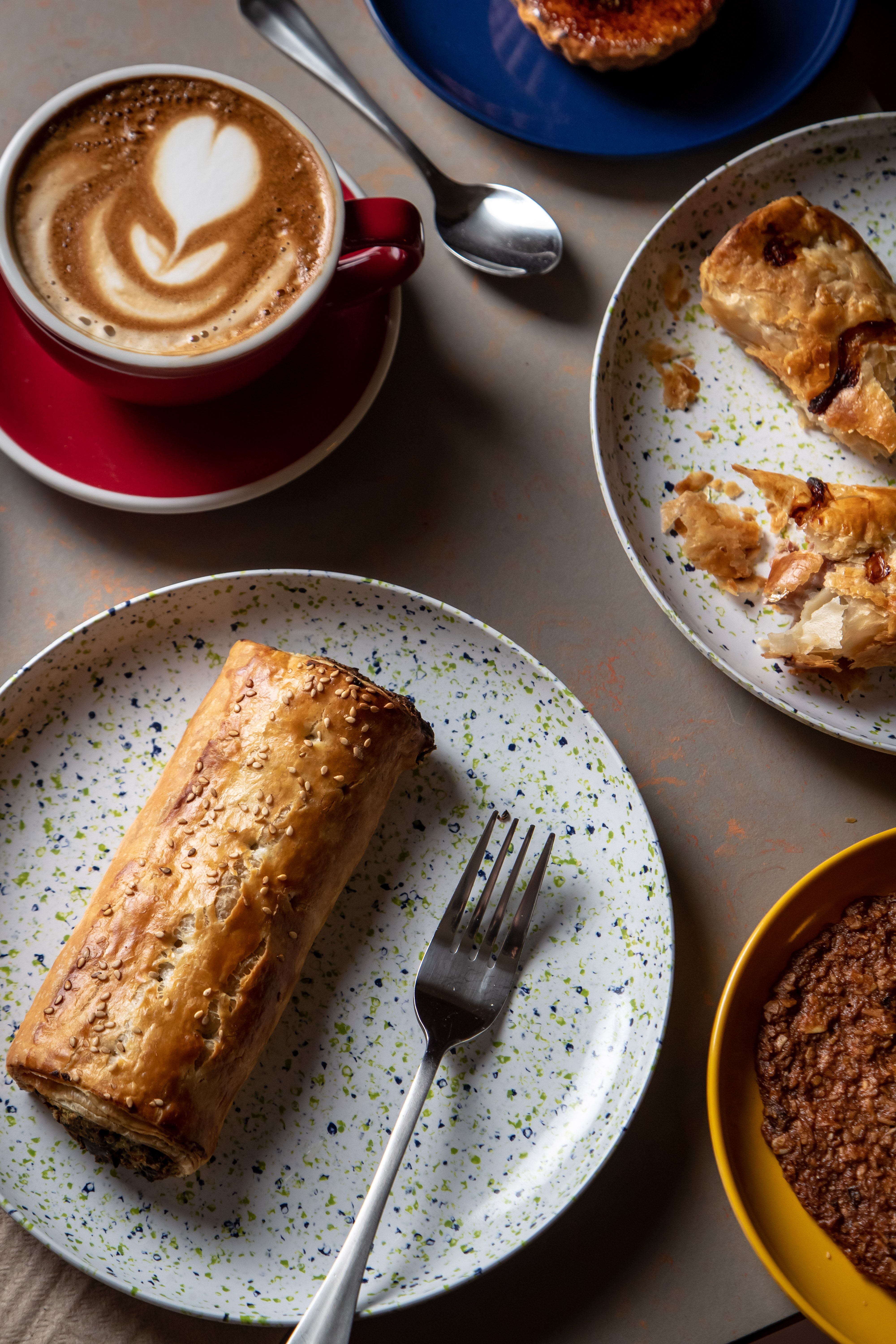 A loaf of bread on a table with a latte