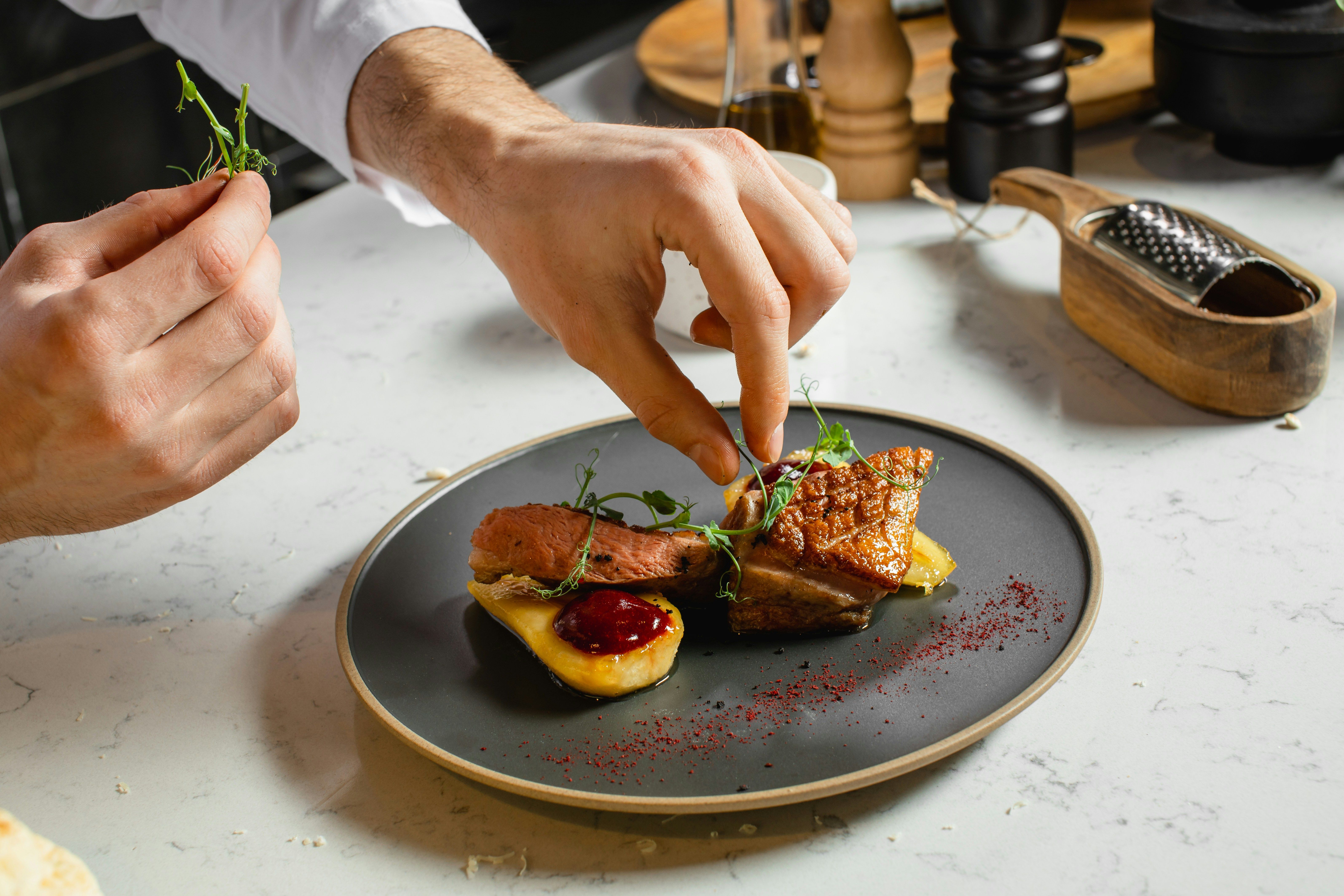 A chef putting a garnish on a dish