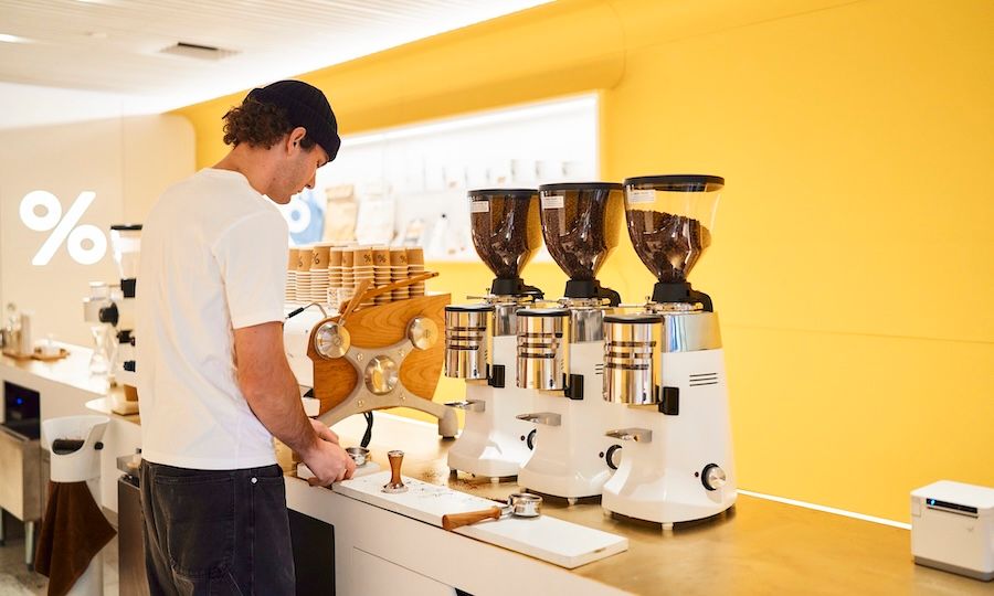 % Arabica employee making a cup of coffee