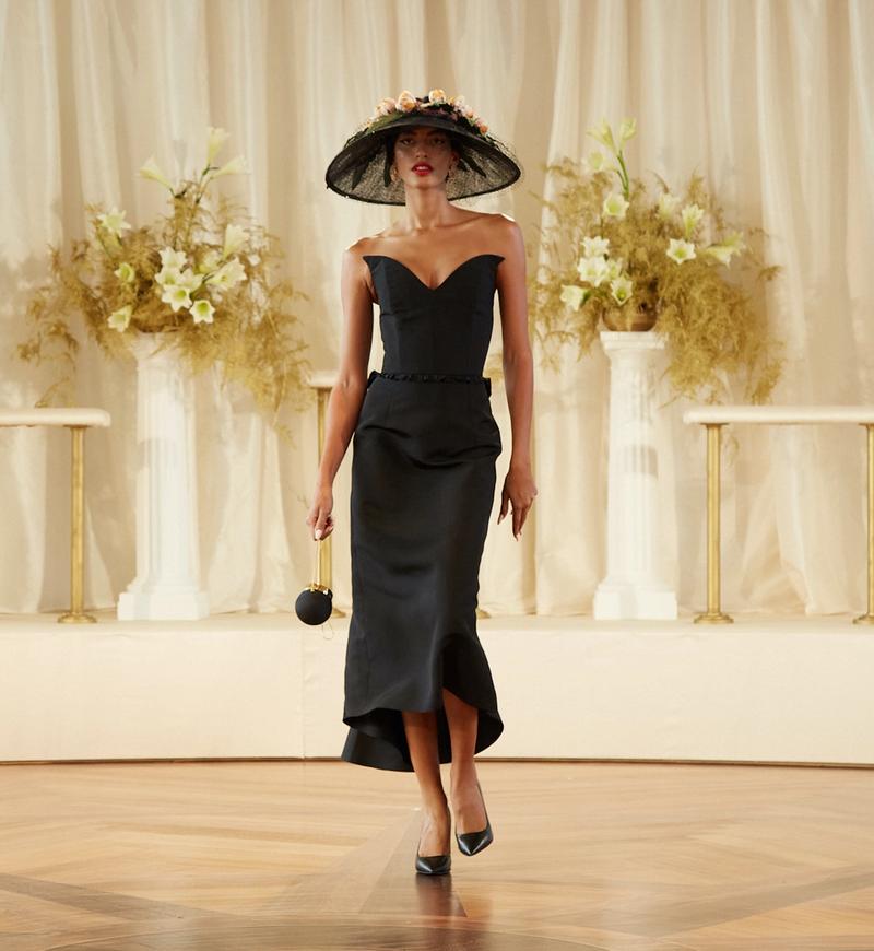 Model in a black dress and hat in Markarian's Spring/Summer 2022 runway show at the Rainbow Room