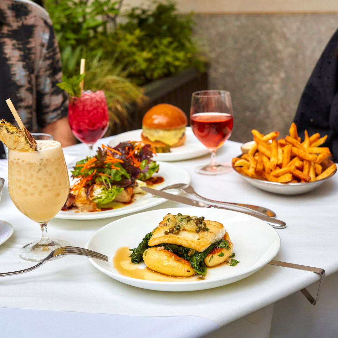 Various dishes and drinks on a table on Le Rock's outdoor terrace
