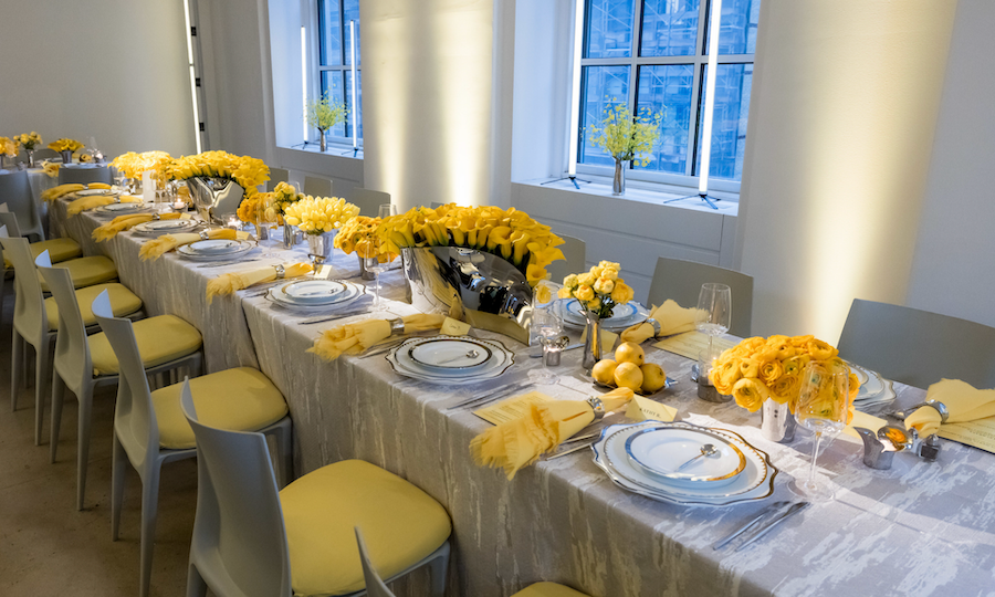 Dining table decorated with yellow flowers and linens at 610 Loft & Garden