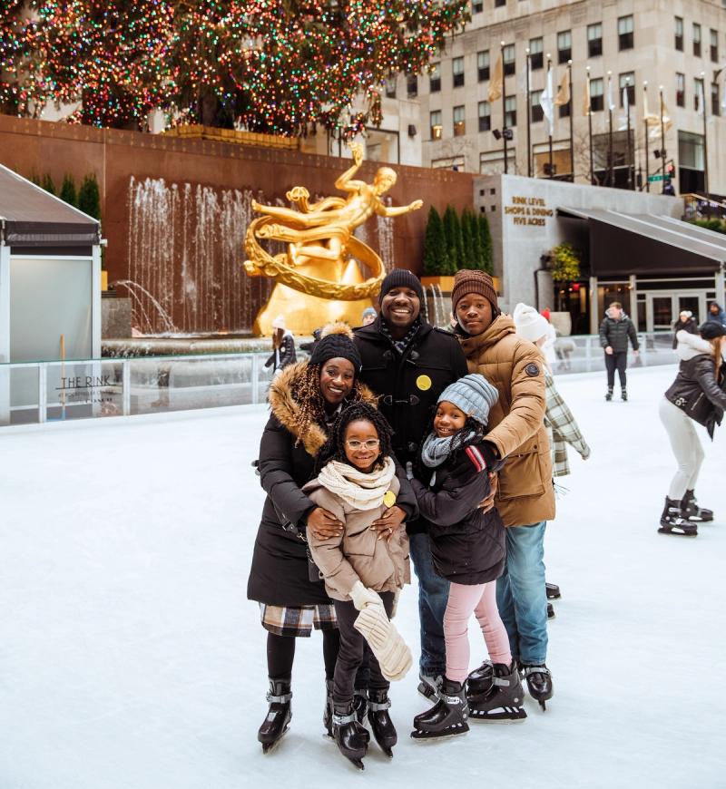 Family of five ice skating on The Rink at Rockefeller Center