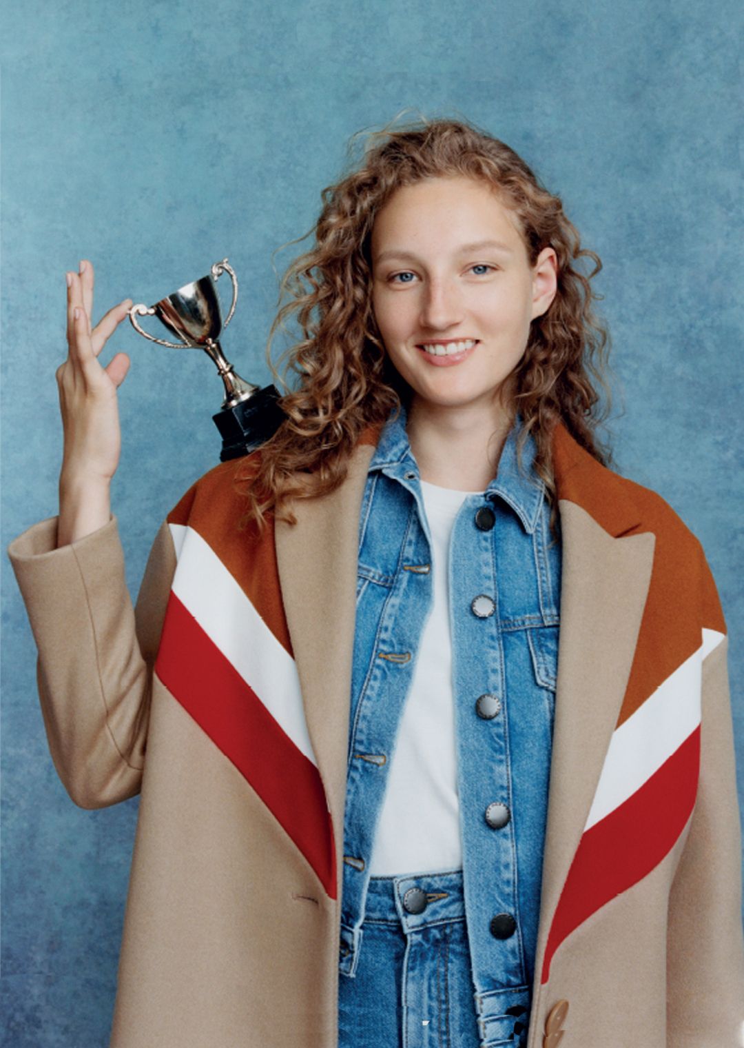 female Maje model holding a trophy 