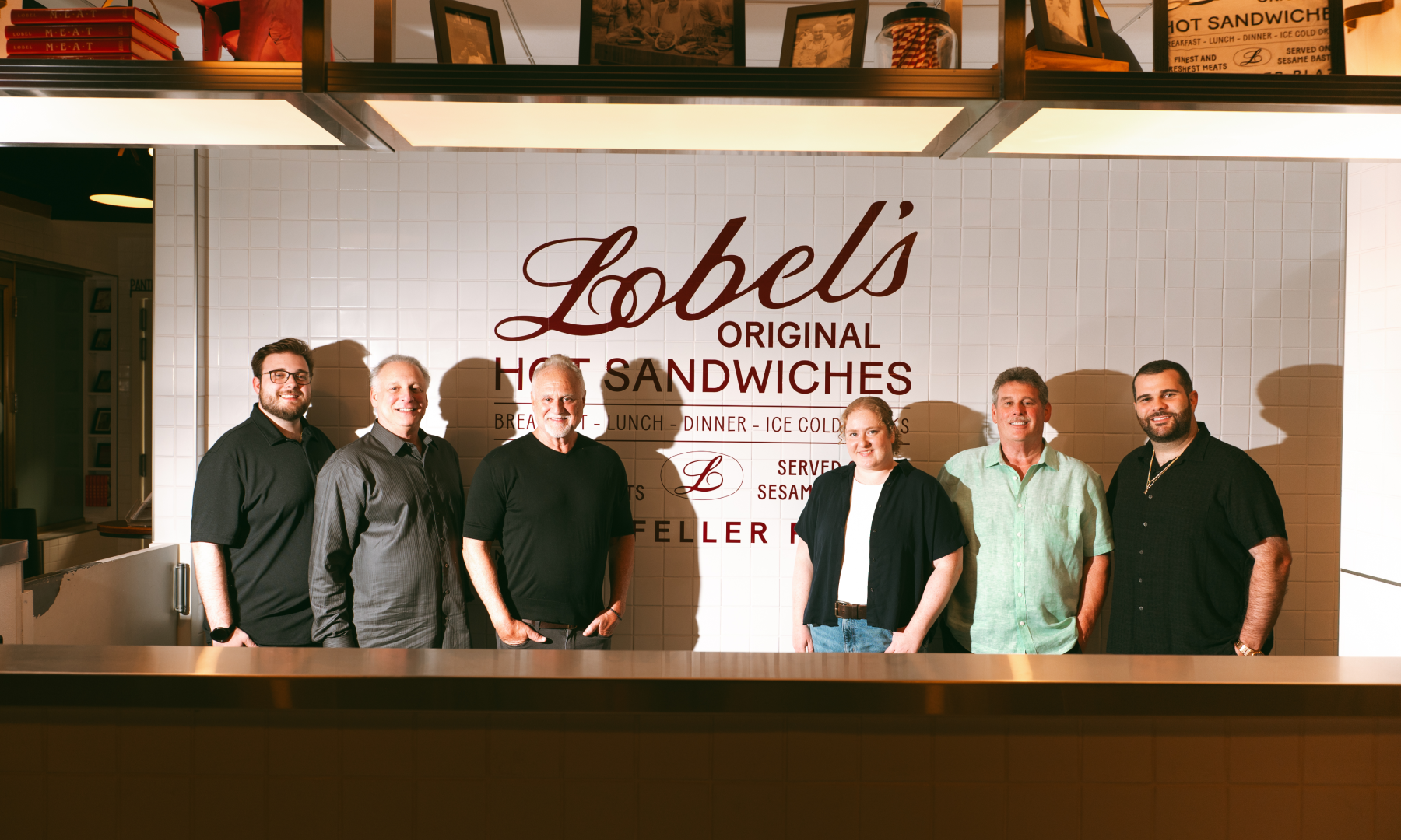 The Lobel family posing for a photo inside Lobel's Original at Rockefeller Center