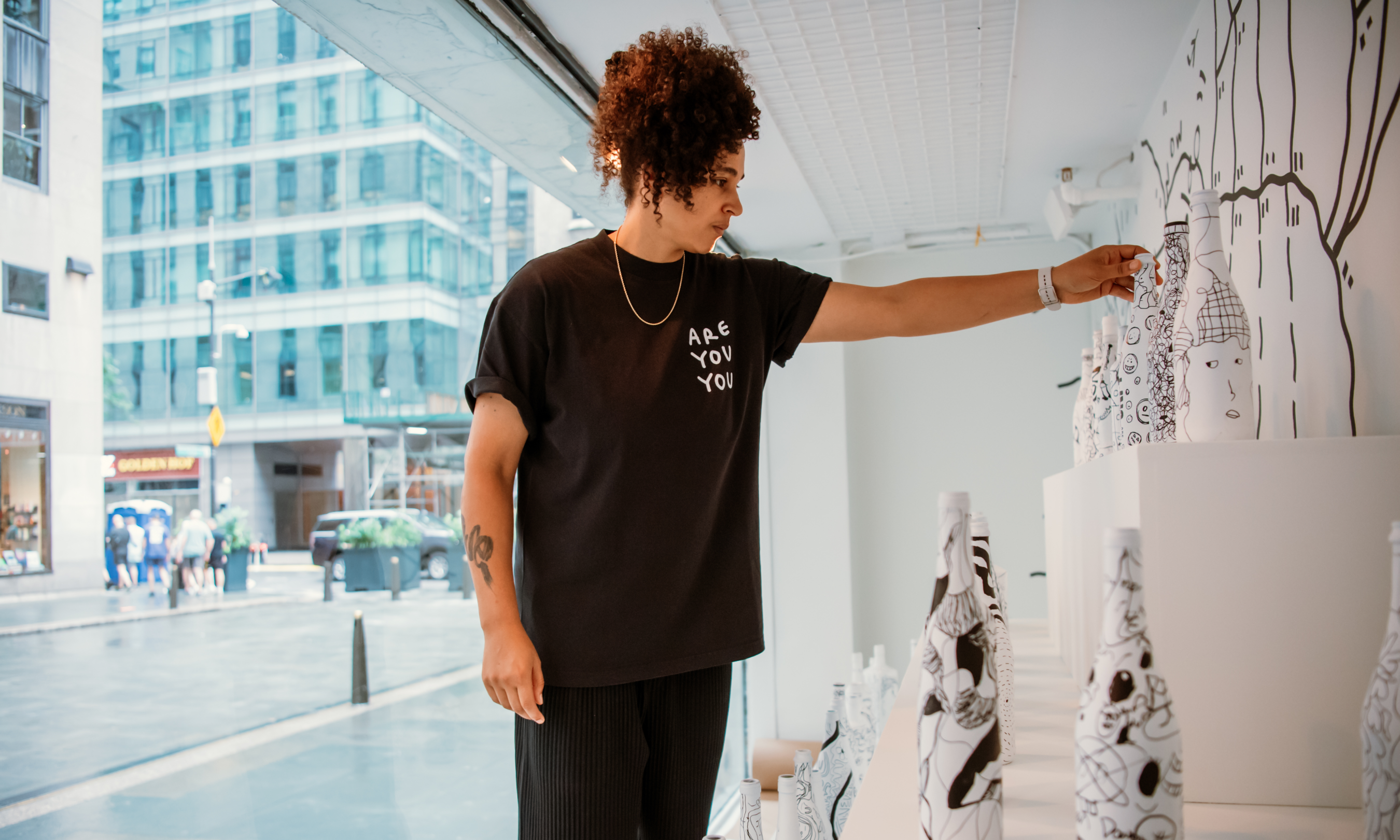 Artist Shantell Martin fixing a display of artwork done during an Art Sundae children's art workshop