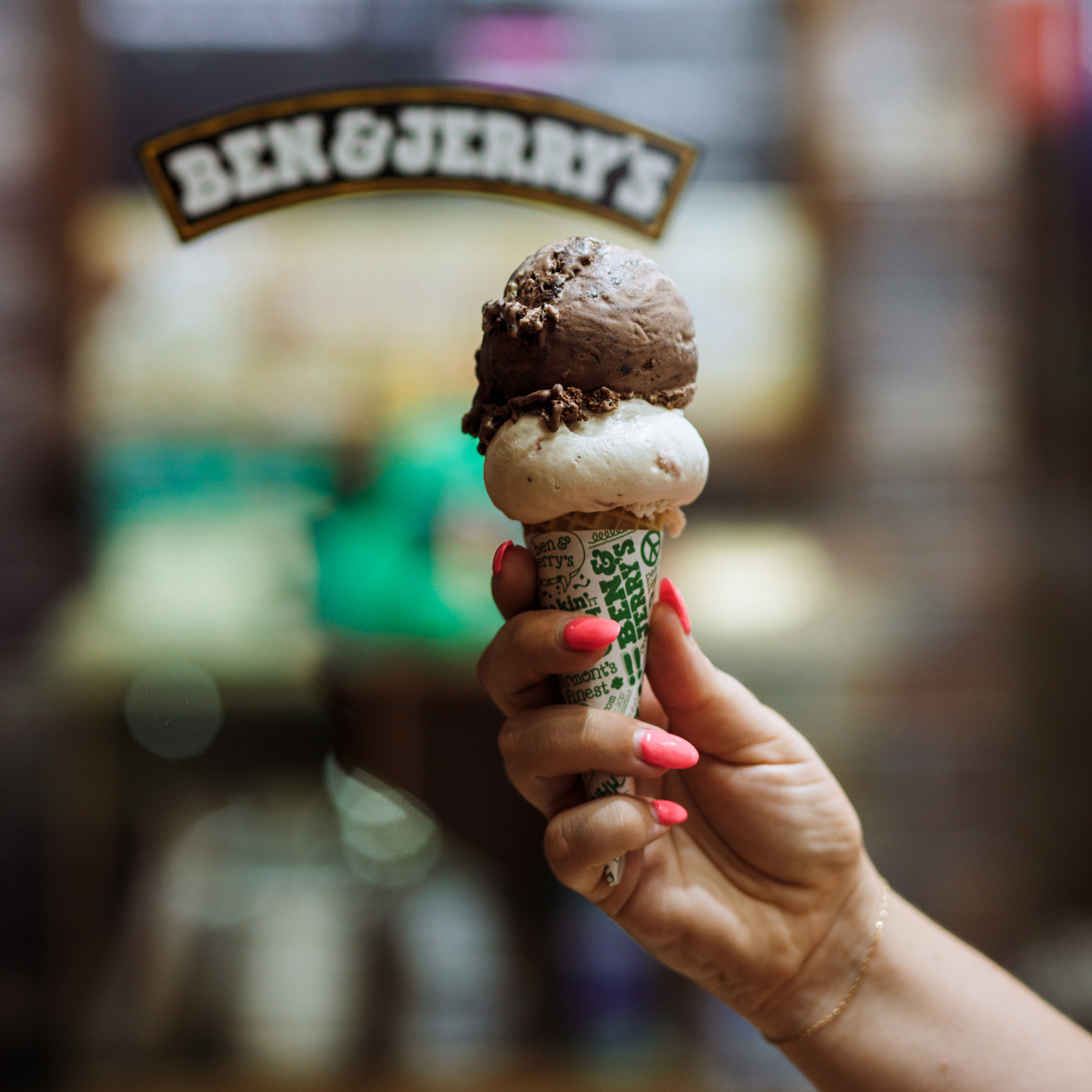 Hand holding an ice cream cone with two scoops of Ben & Jerry's ice cream