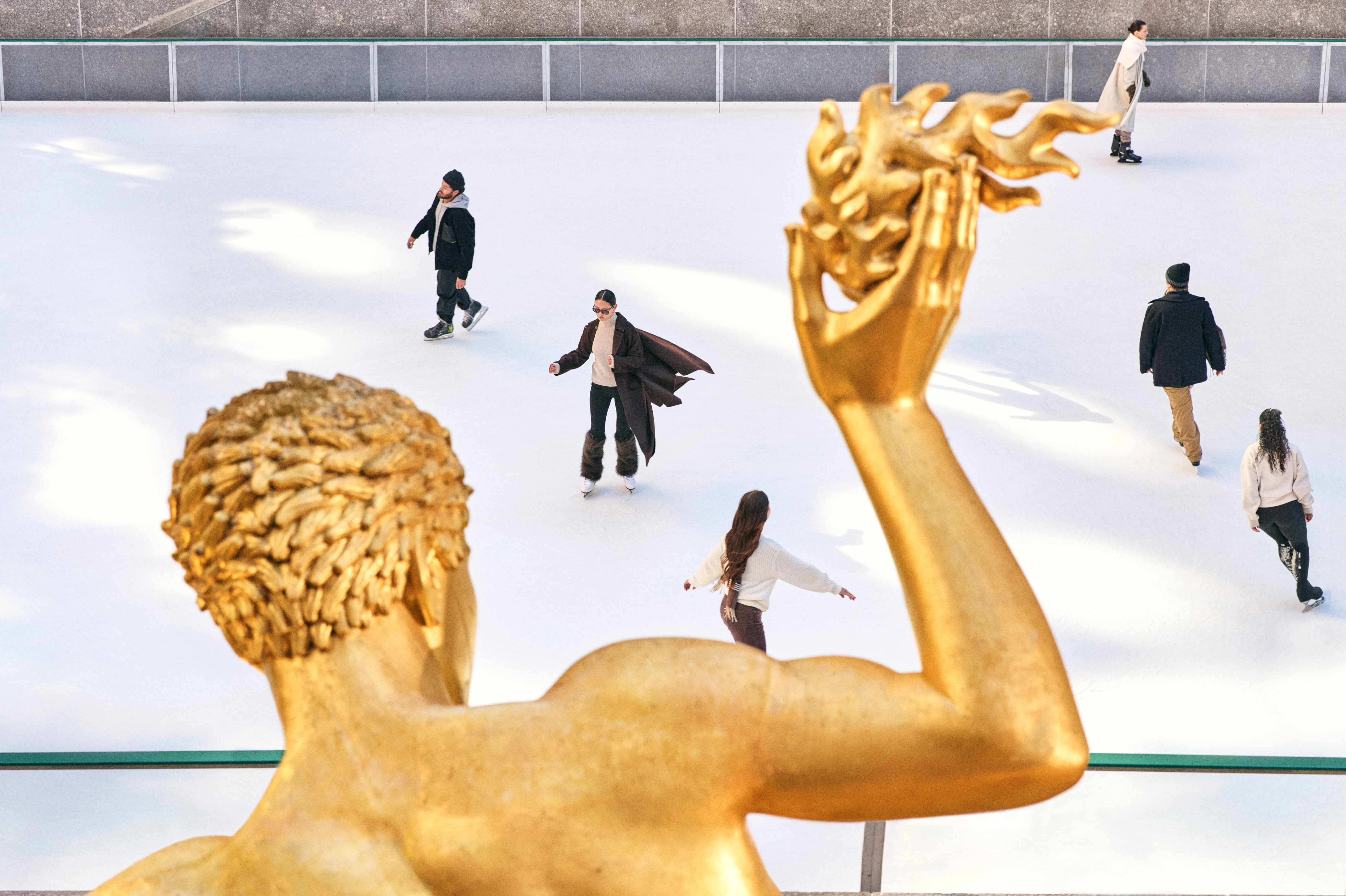Skaters on the rink at rockefeller center under the prometheus statue