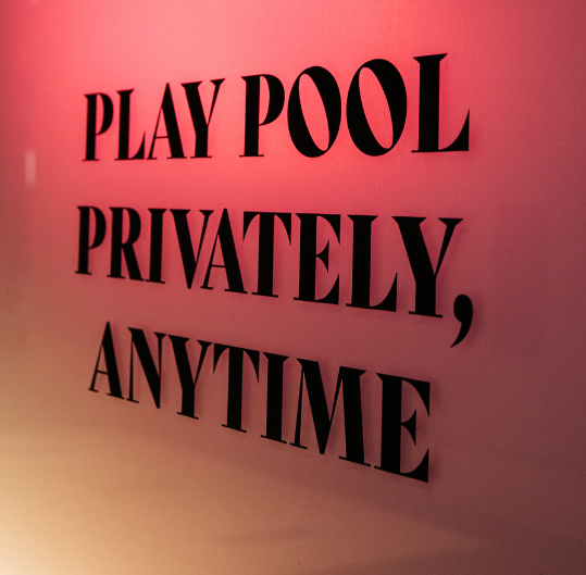 A sign at Sharks Pool Club in Rockefeller Center that reads "Play Pool Privately, Anytime"