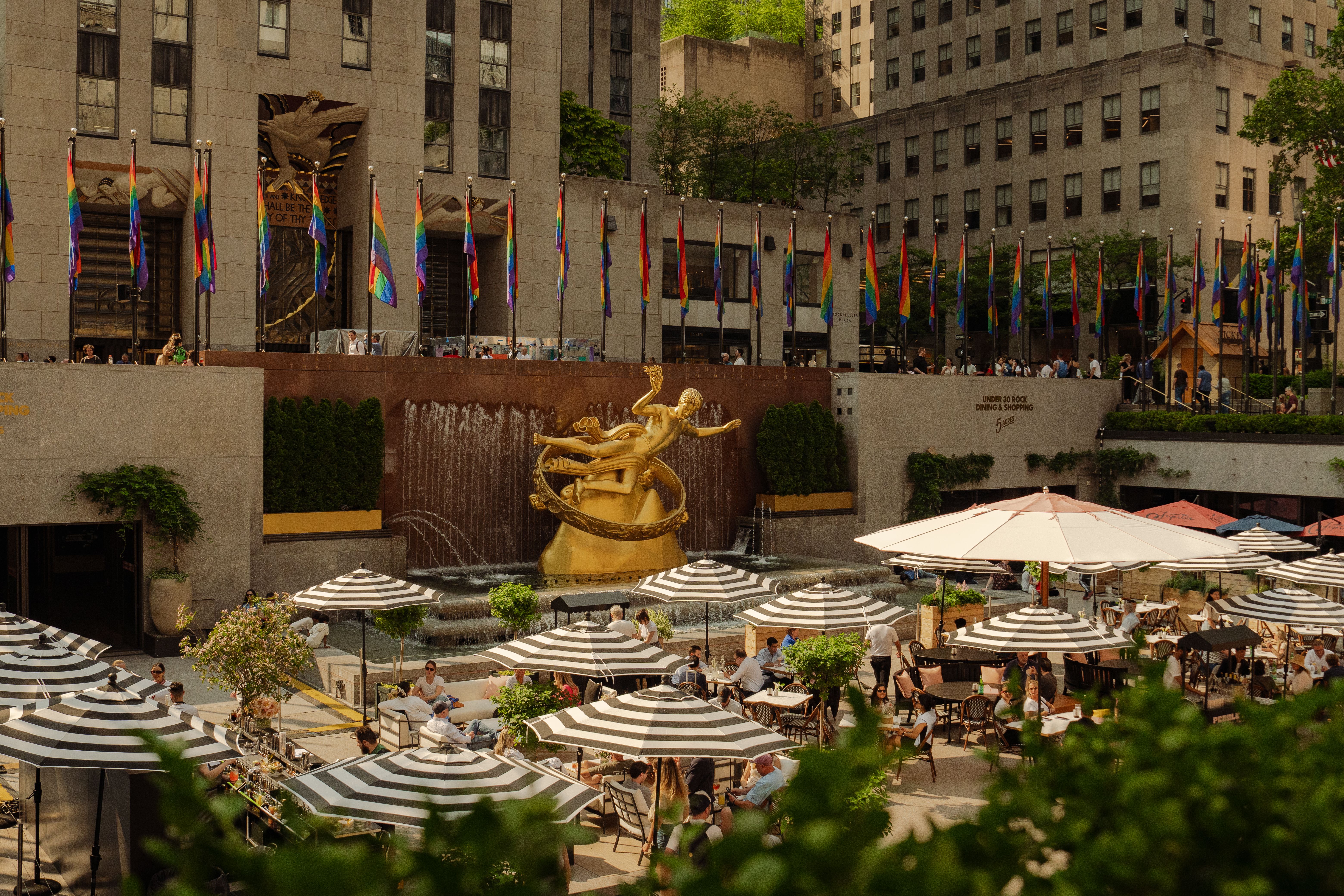 the summer rink at rockefeller center with striped umbrellas and tables