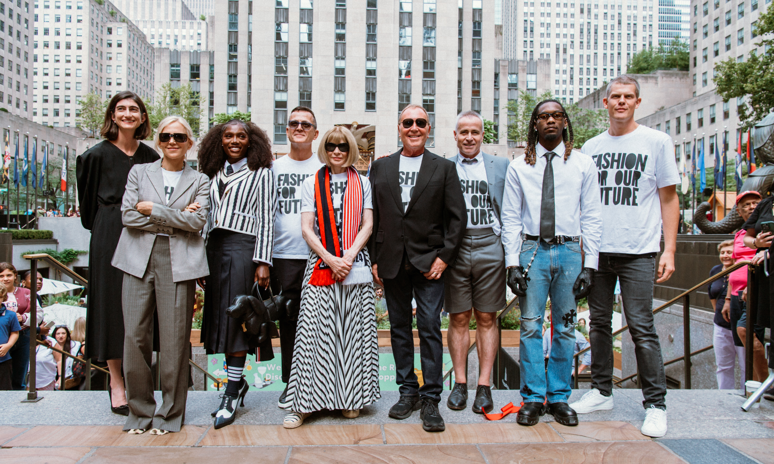 Rockefeller Center staff, fashion designers, and celebrities posing for a photo at Rockefeller Center