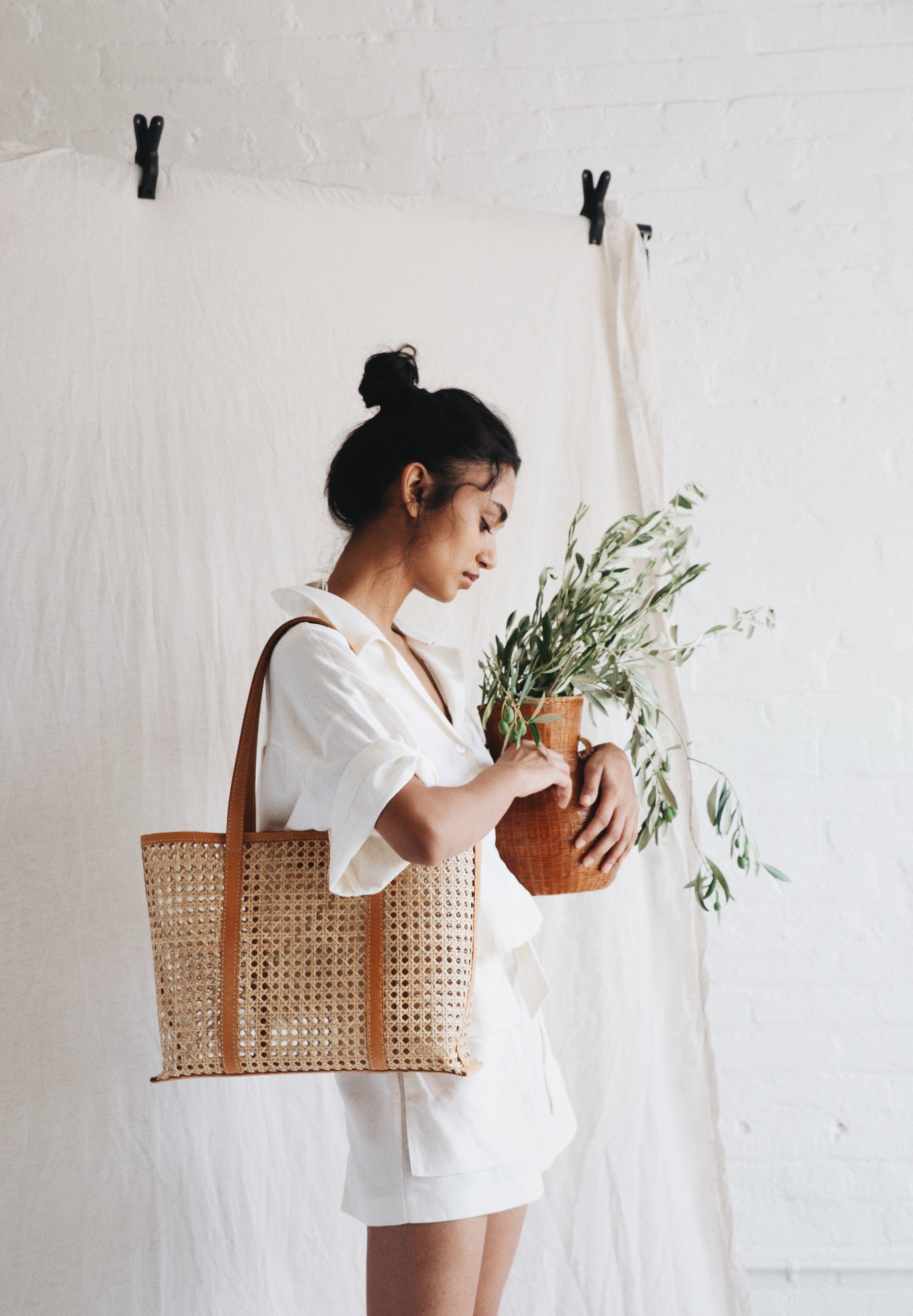 Model holding Bembien beach bag on white backdrop