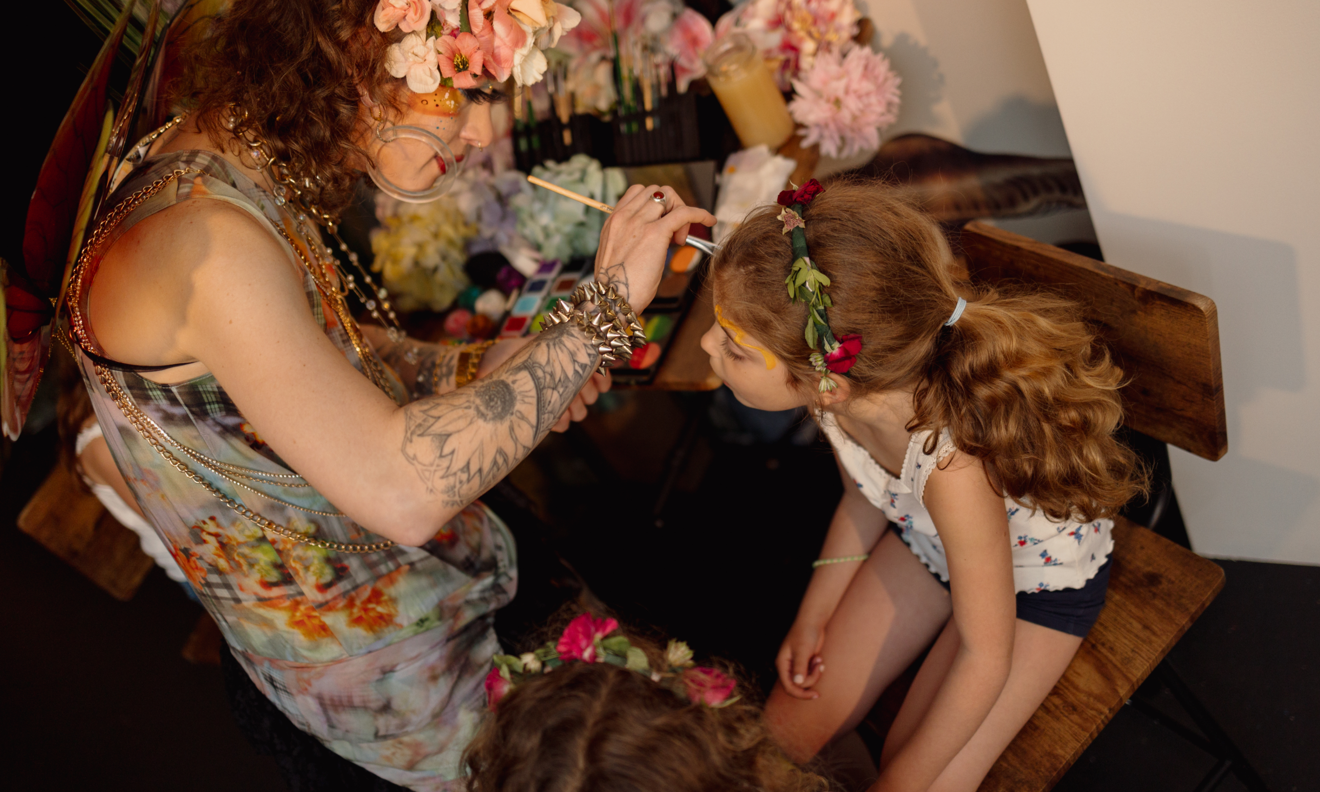 Artist applying face paint on a child at BLOOM at Rockefeller Center