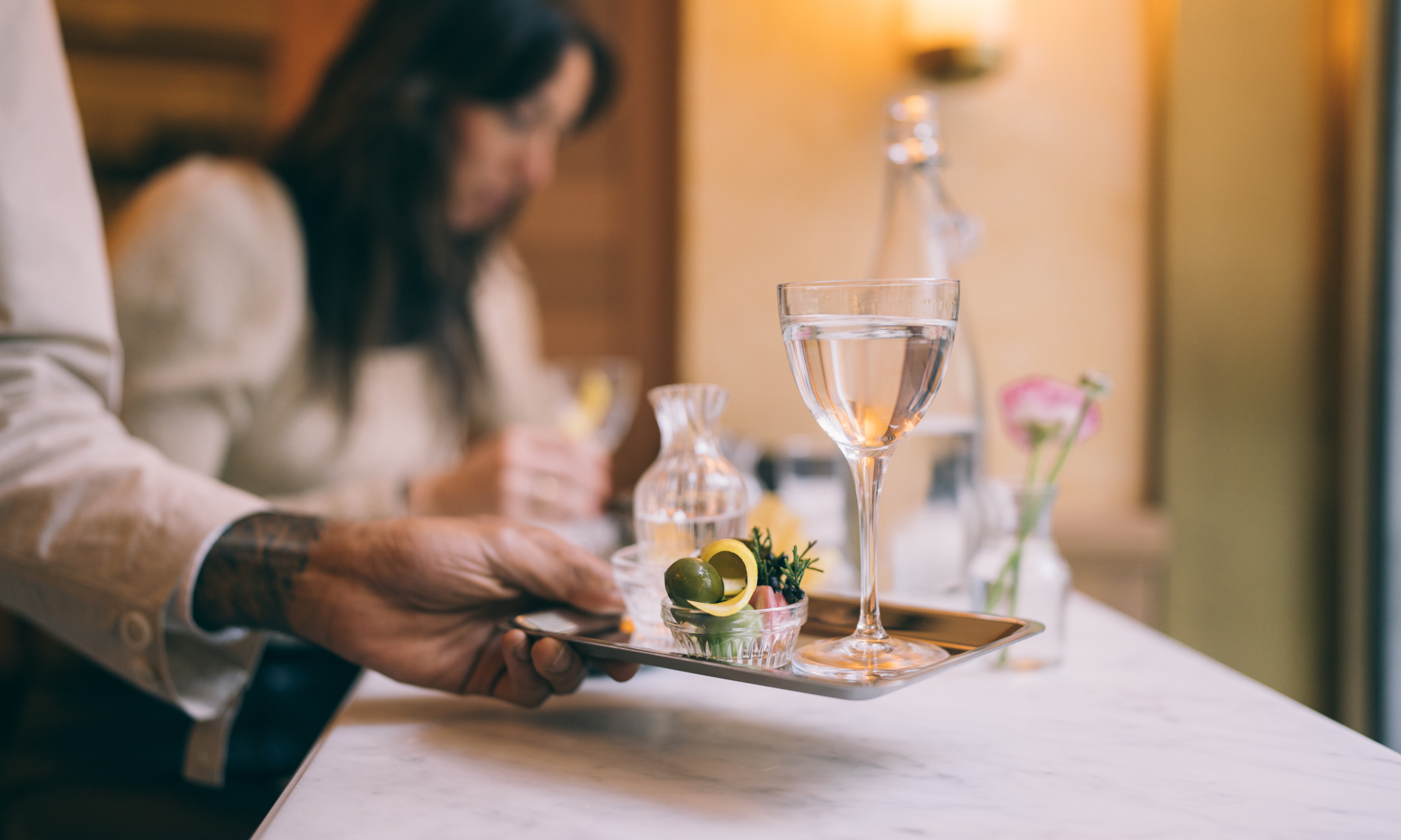 Serving holding a tray with Lodi's Rockefeller Martini