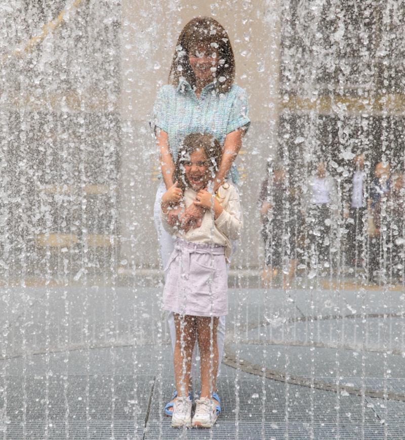Mother and daughter interacting with artist Jeppe Hein's 