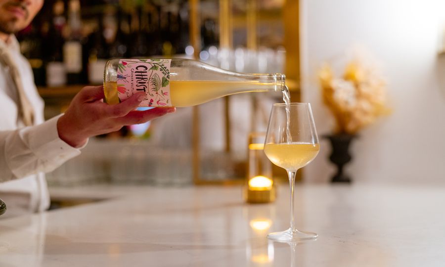 Server pouring white wine into a glass at The Tipsy Baker at Rockefeller Center