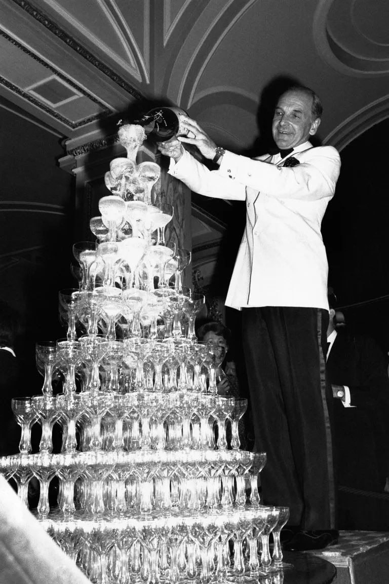 A man pouring Champaign into a Champaign tower 