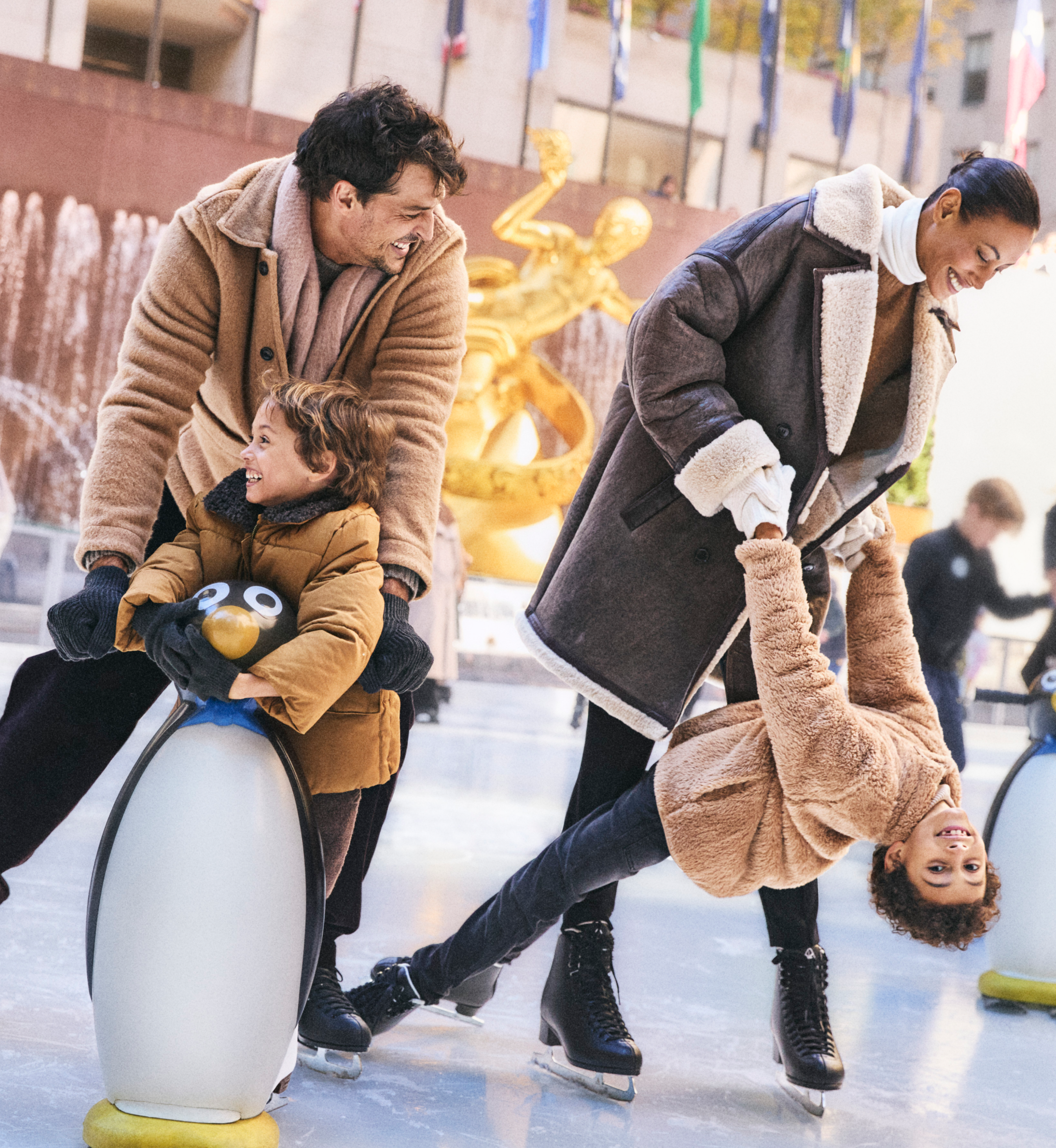A family of four ice skating at The Rink at Rockefeller Center