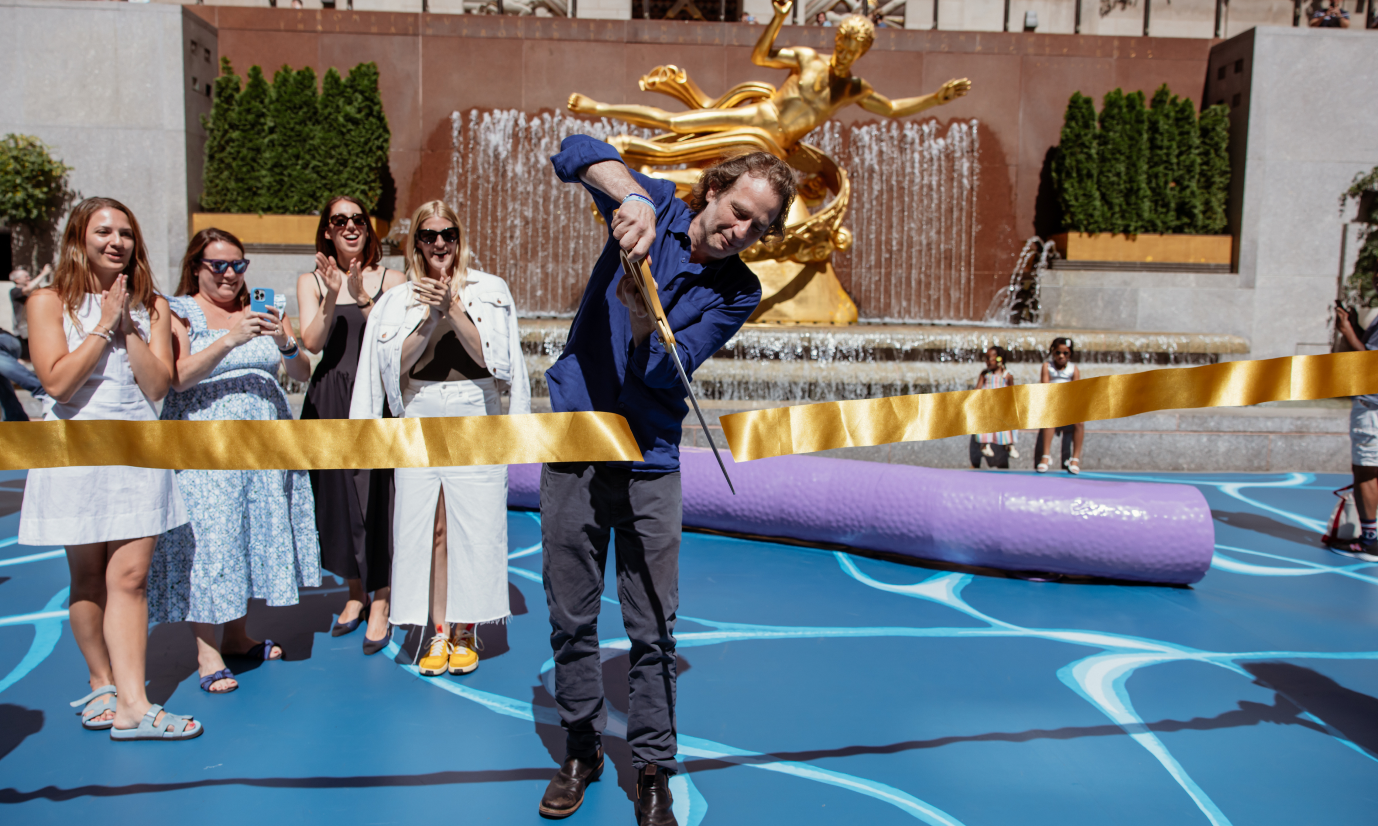 Artist Joel Mesler cuts the ribbon at the opening of his new public art installation at Rockefeller Center