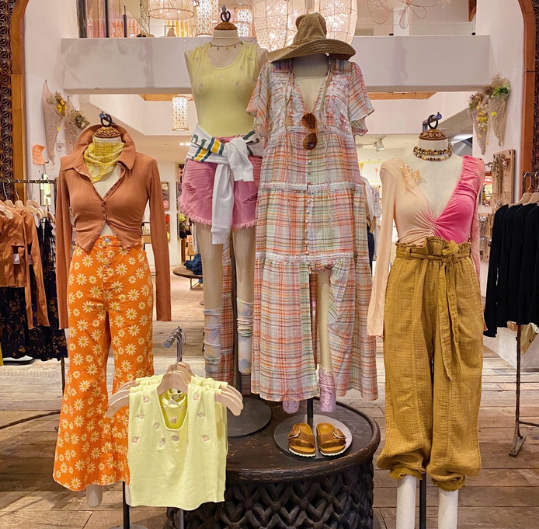 Image of an in-store free people display that showcase multiple outfits with yellow