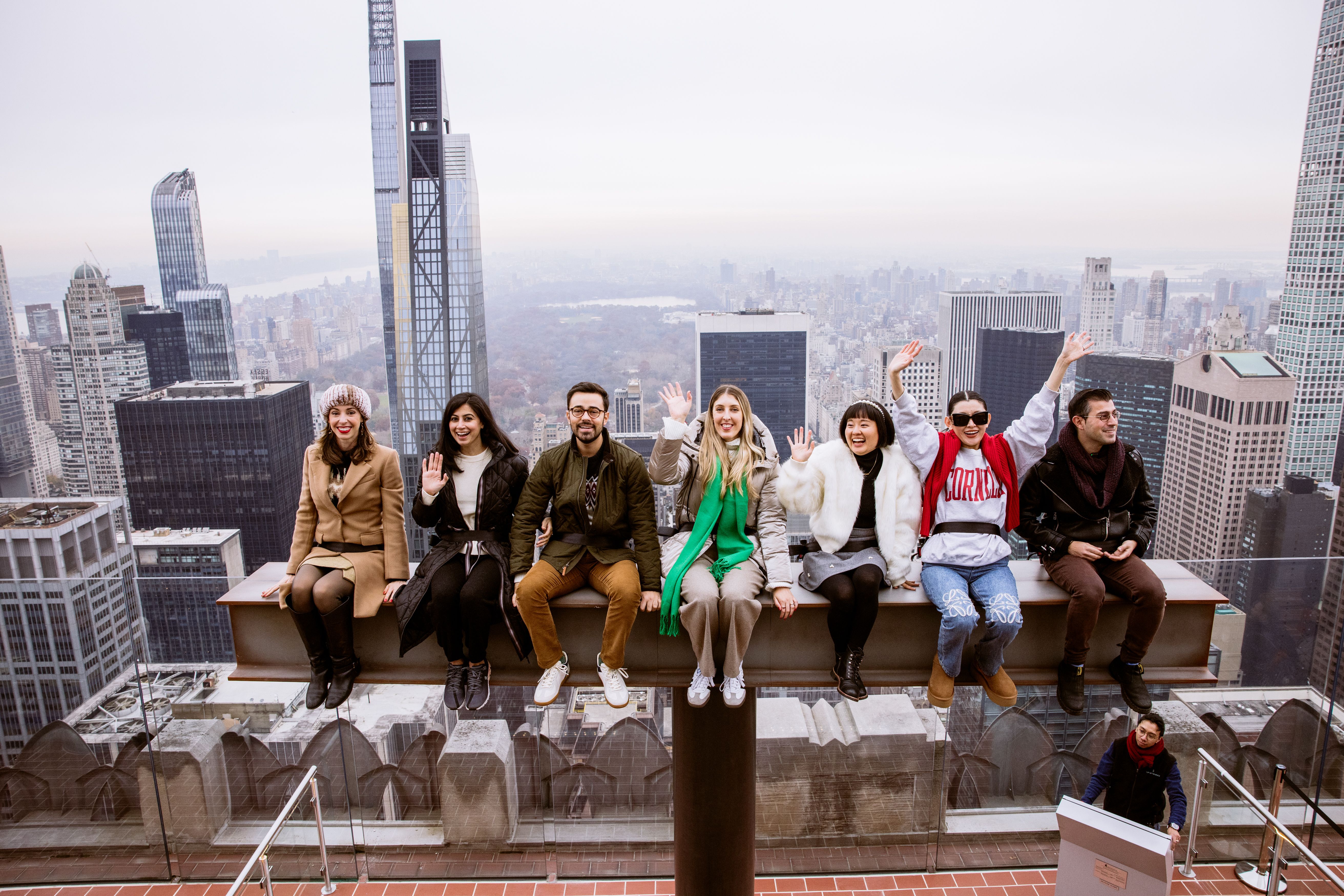 people waving and riding the beam