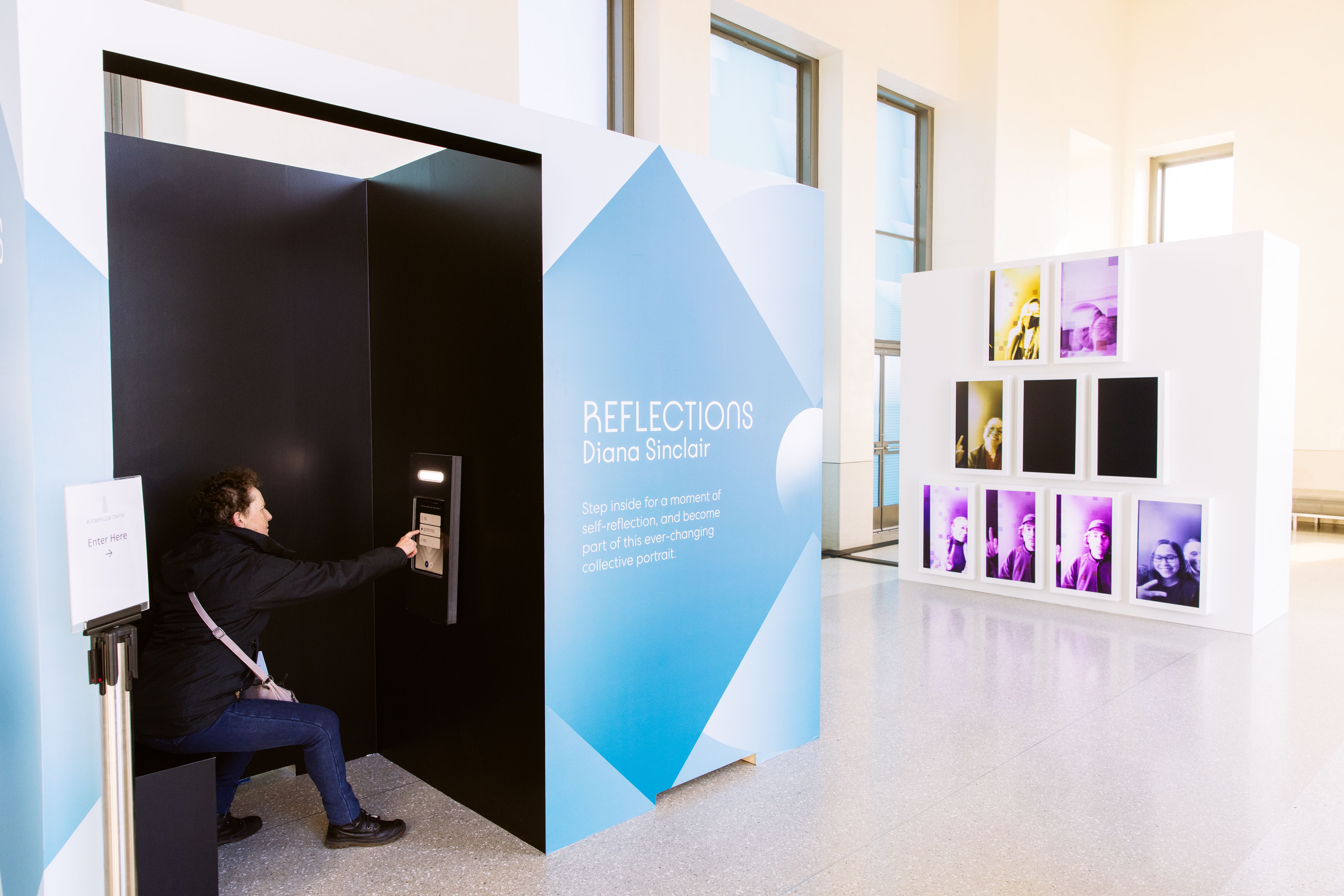 Person taking a portrait for artist Diana Sinclair's "Reflections" exhibit at Top of the Ro