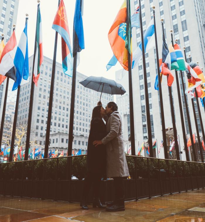 A couple kissing in the rain at Rockefeller Center