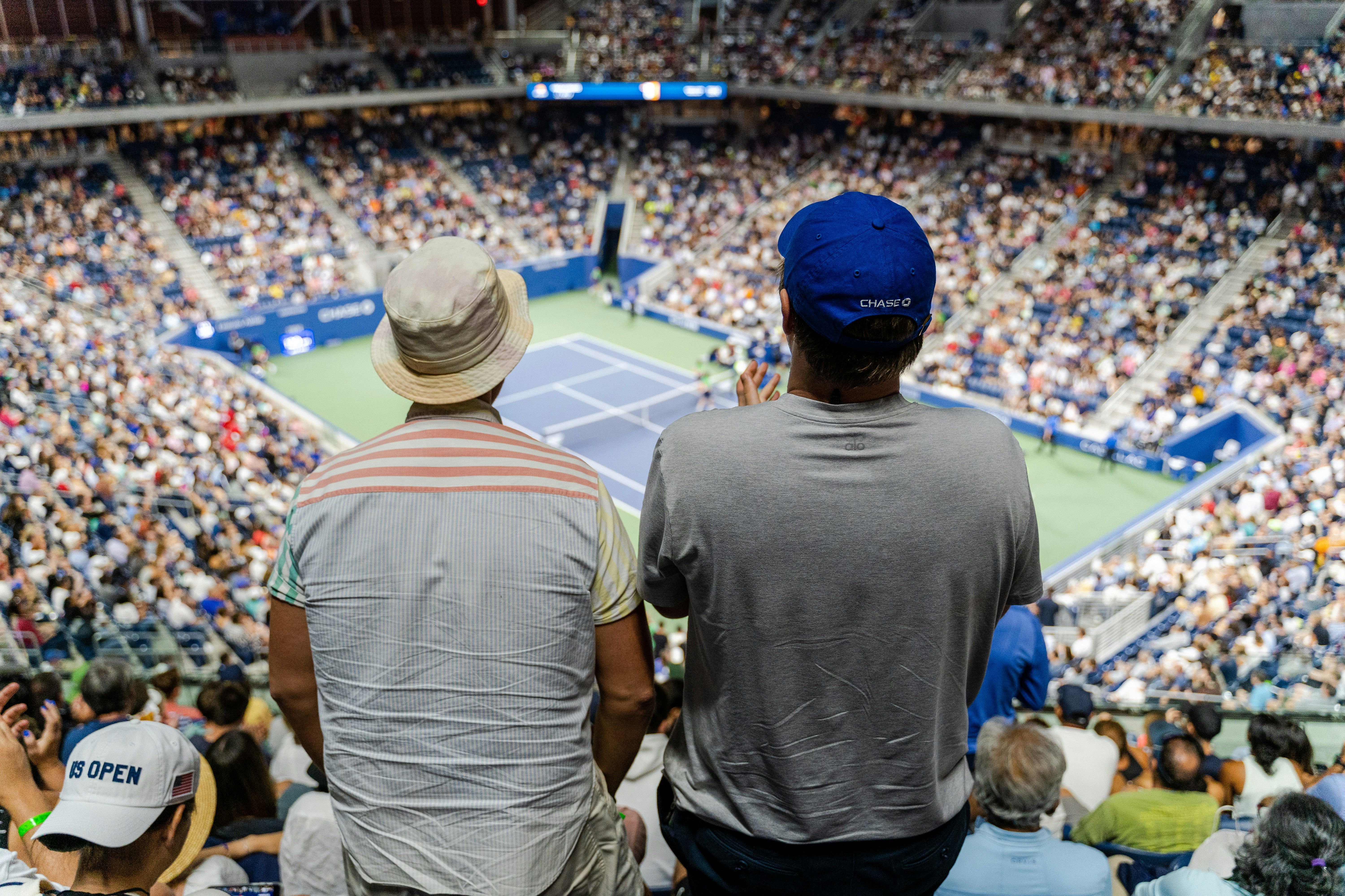Two fans stand to cheer on tennis action during the 2022 US Open in New York City, Flushing, Queens, NY.