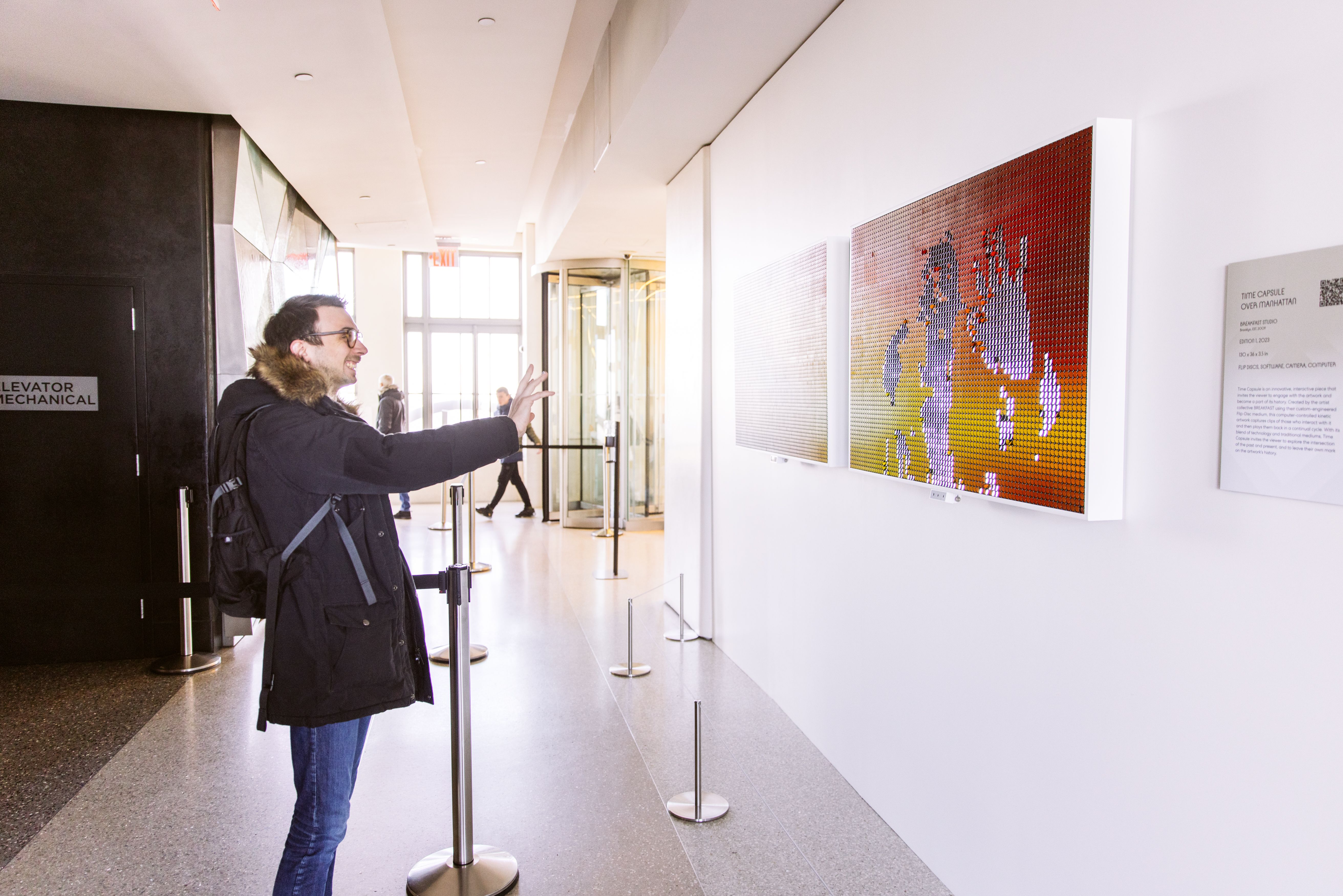 Person interacting with Breakfast Studio's kinetic sculpture at Top of the Rock