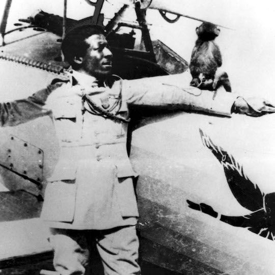 Eugene Bullard standing in front of a plane with his pet monkey Jimmy