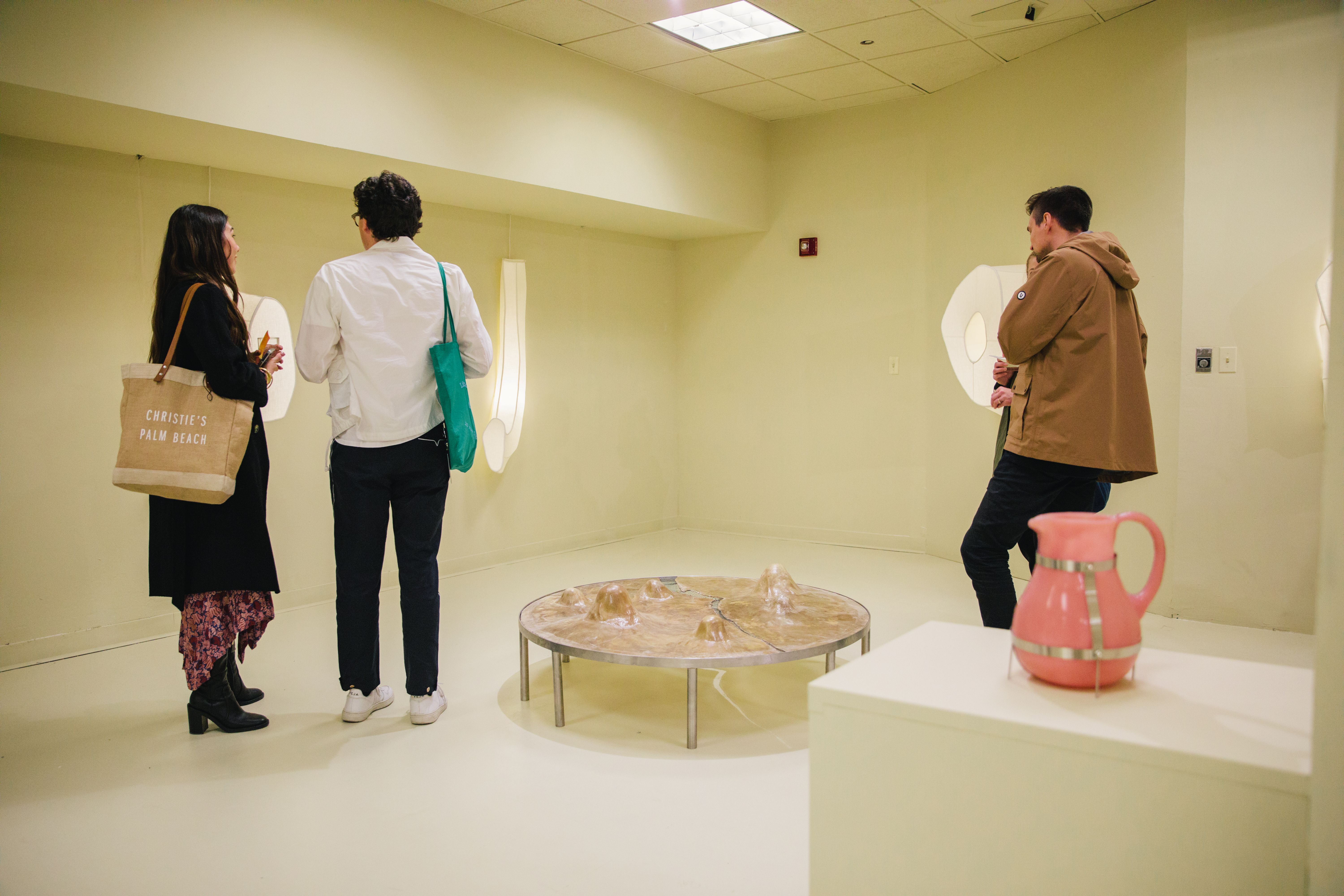 People viewing mounted light sculptures at MASA's exhibition at Rockefeller Center