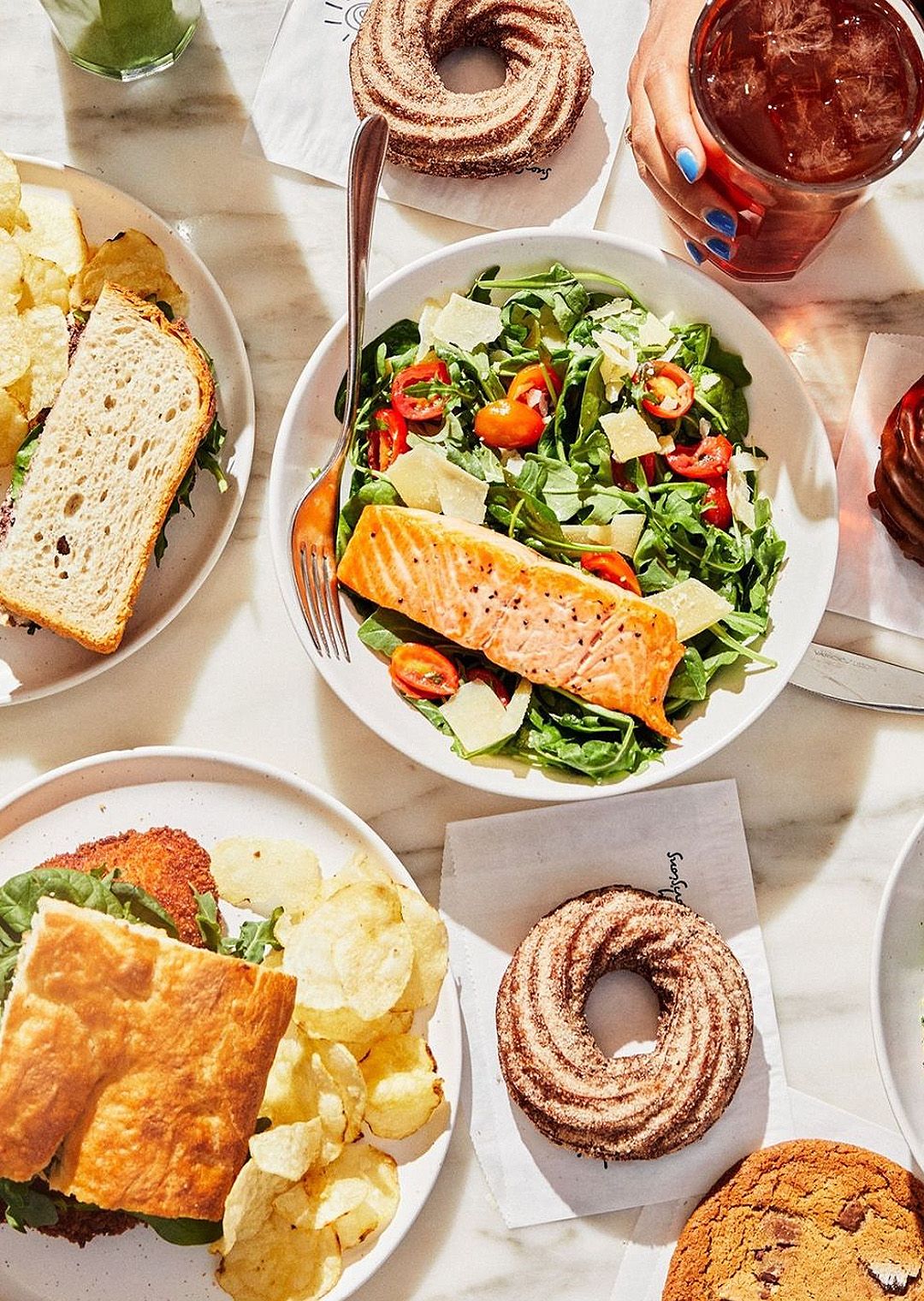 Salad, sandwich and donuts on a table