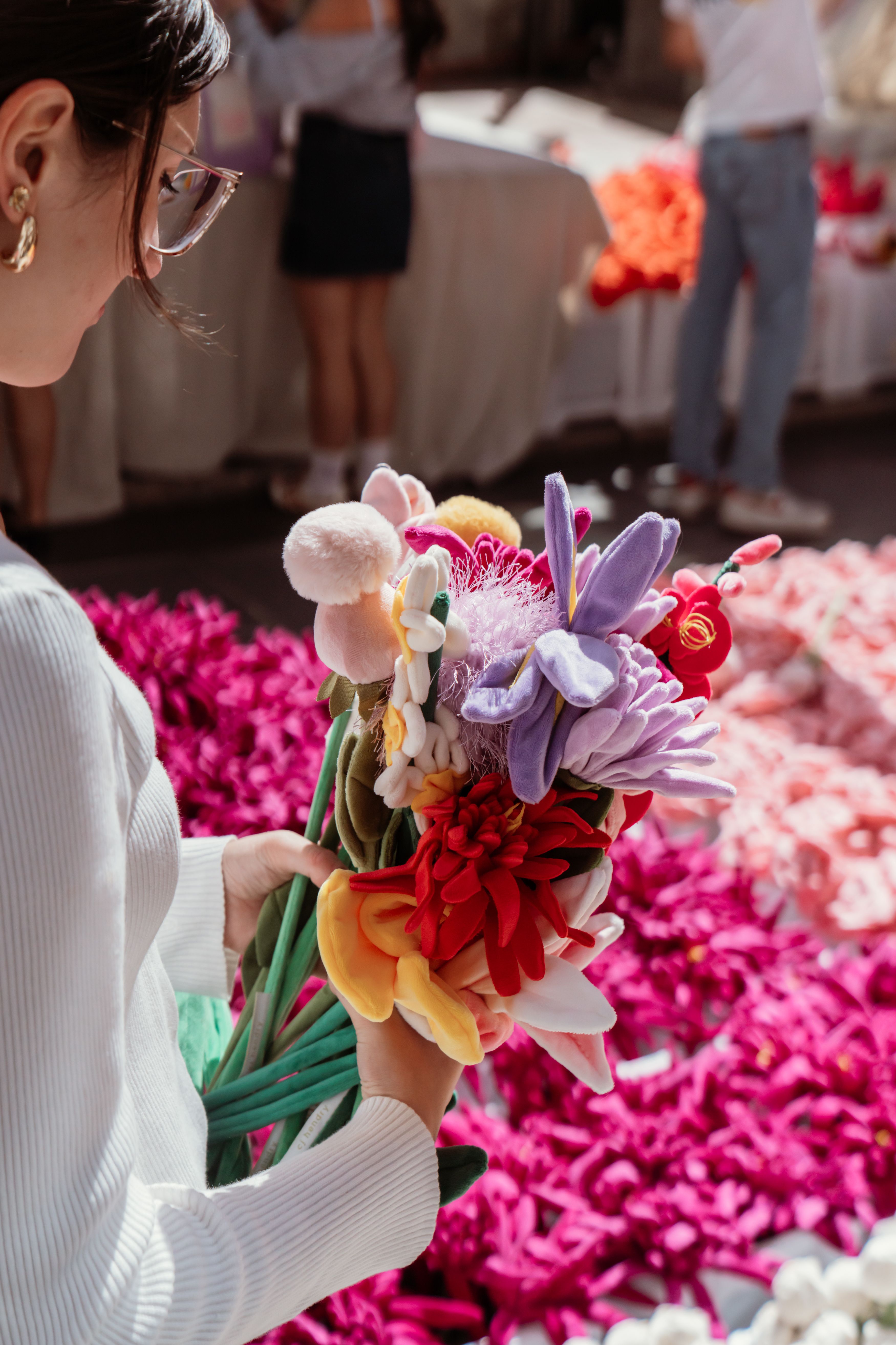 A visitor builds a bouquet of plush flowers at Cj Hendry's installation