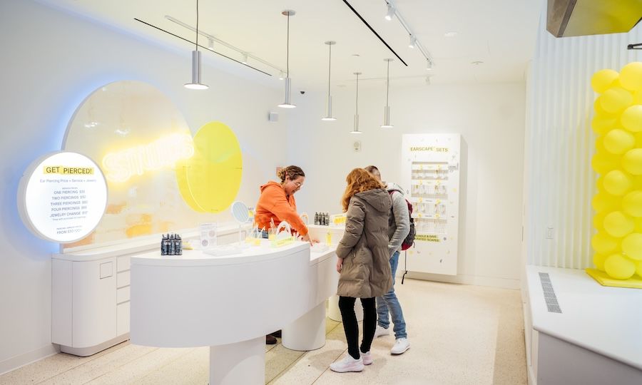 Two people and an employee browsing Studs' earring selection