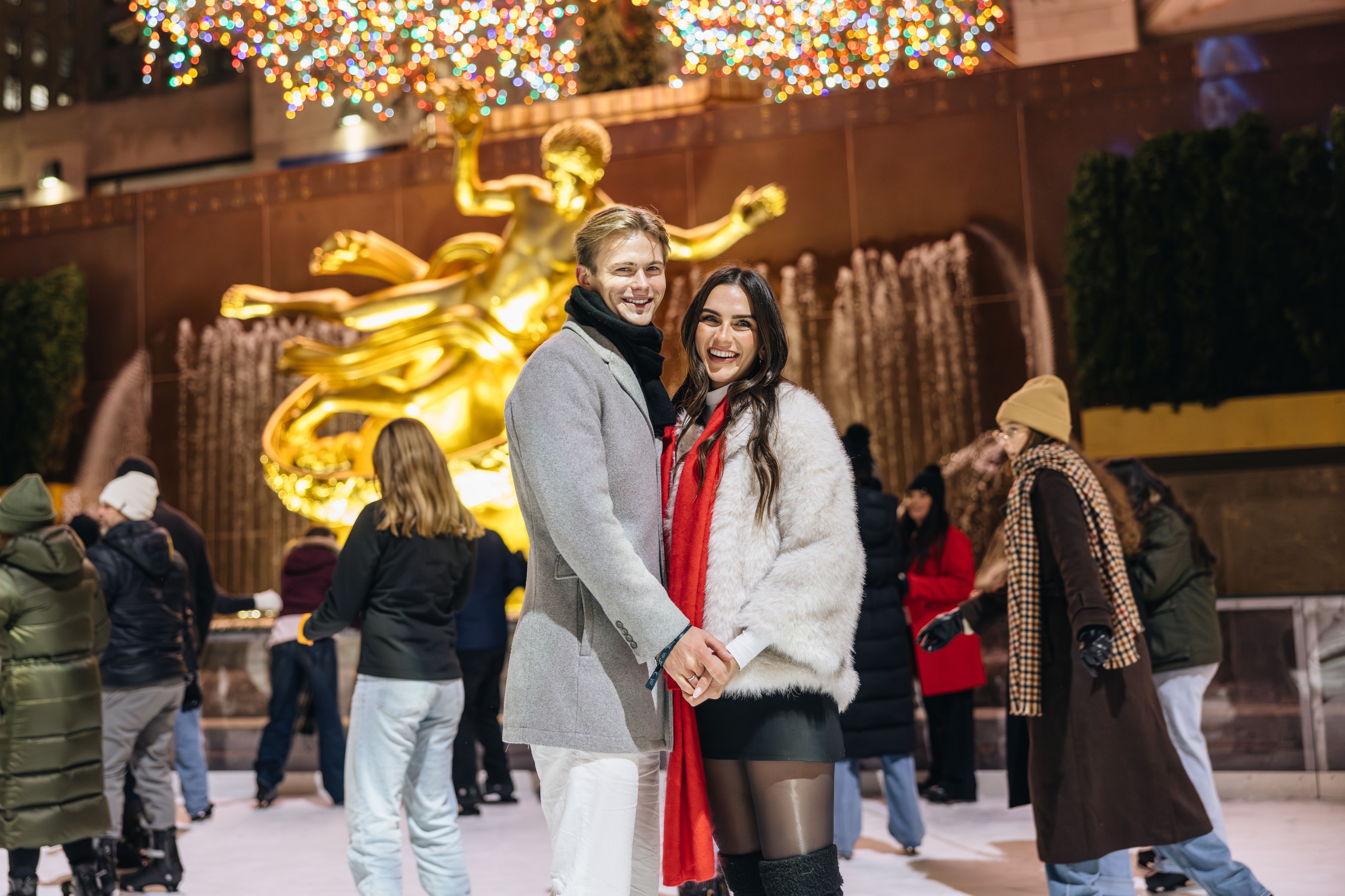 two skaters smiling at the rink at rockefeller center