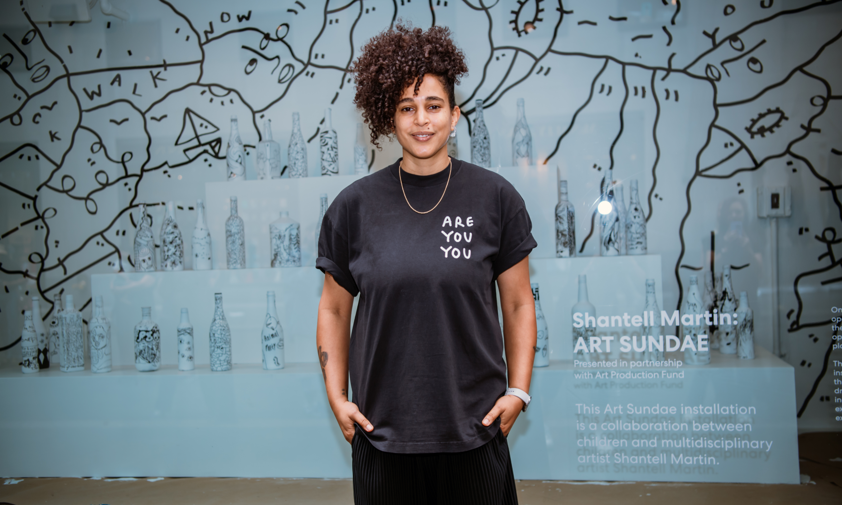 Artist Shantell Martin posing in front of a window display