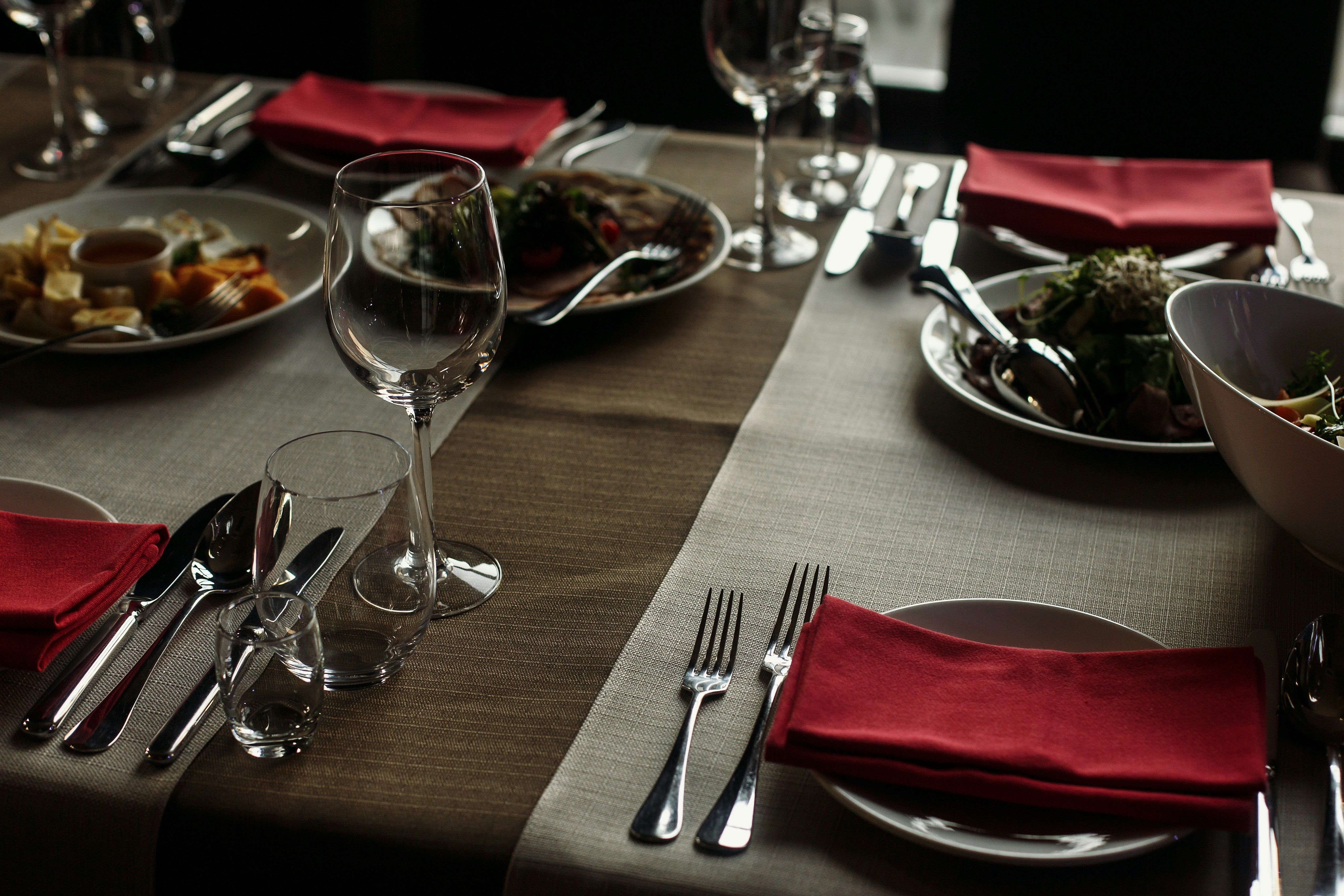 a dining table with wine glasses and salad