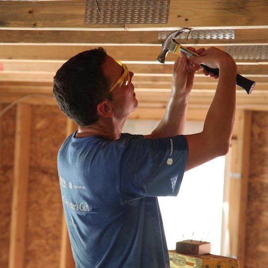 Habitat for Humanity volunteer setting up beams in a new home